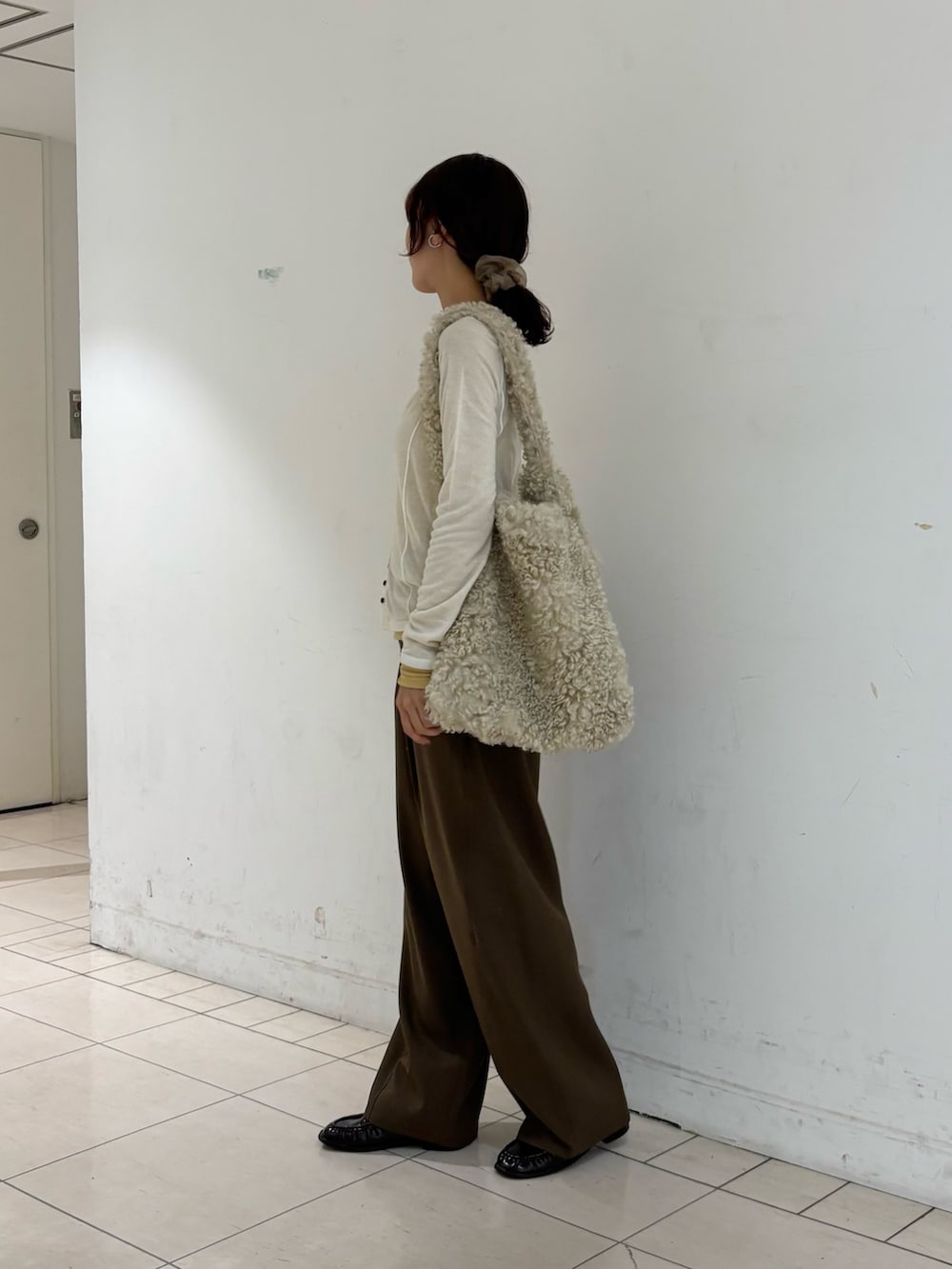 ブラウン系のその他パンツ、ホワイト系のTシャツ/カットソー、ホワイト系のショルダーバッグを着用したレディースの秋コーディネートの2枚目の写真