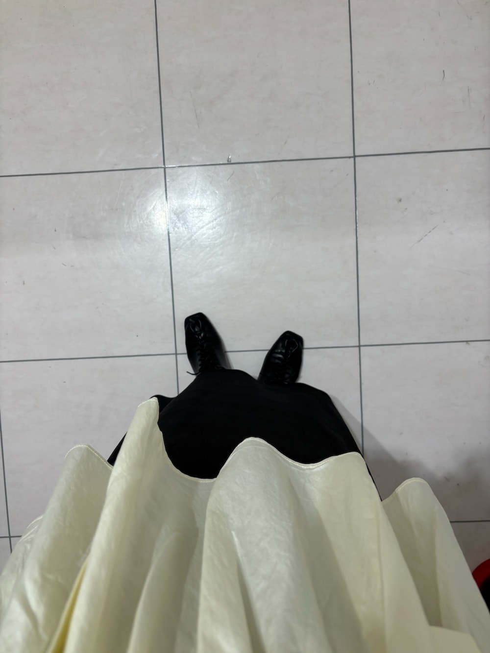 ブラック系のスカート、レッド系のニット/セーター、ホワイト系のその他トップスを着用したレディースの春コーディネートの6枚目の写真