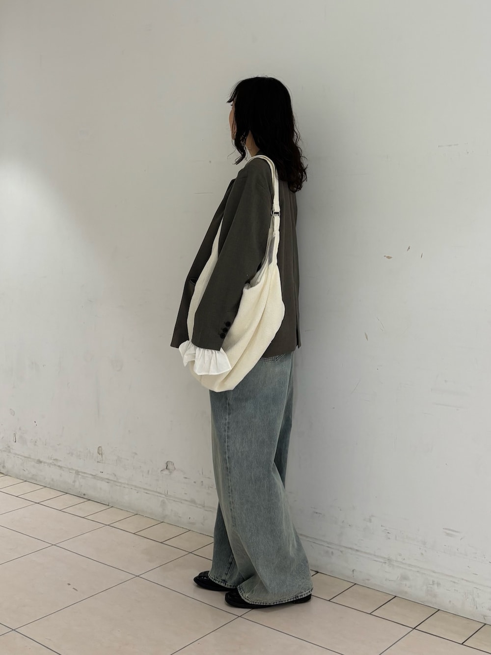 グレー系のその他アウター、イエロー系のTシャツ/カットソー、ブルー系のデニムパンツを着用したレディースの春コーディネートの3枚目の写真