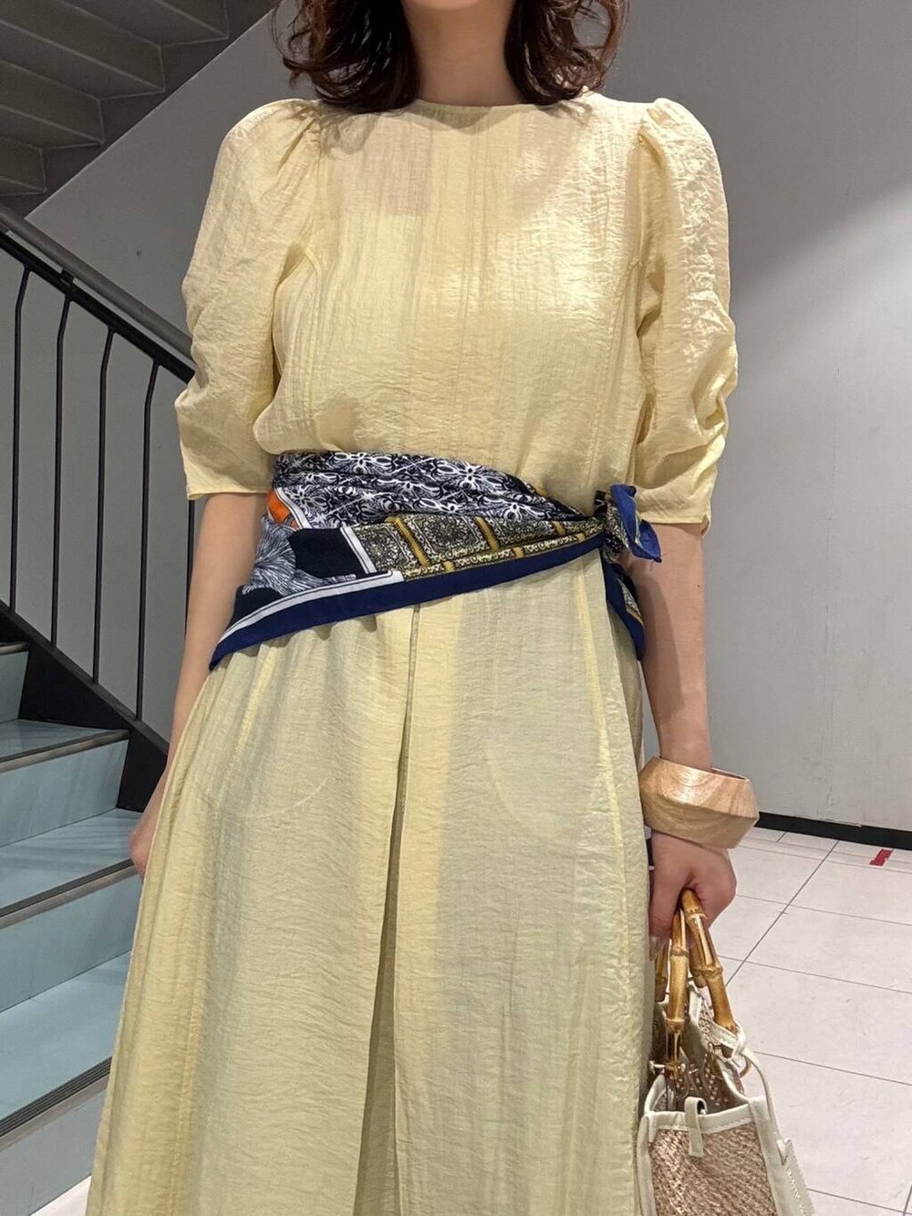 ブルー系のデニムパンツ、イエロー系のその他シューズ、ホワイト系のショルダーバッグを着用したレディースの春コーディネートの6枚目の写真