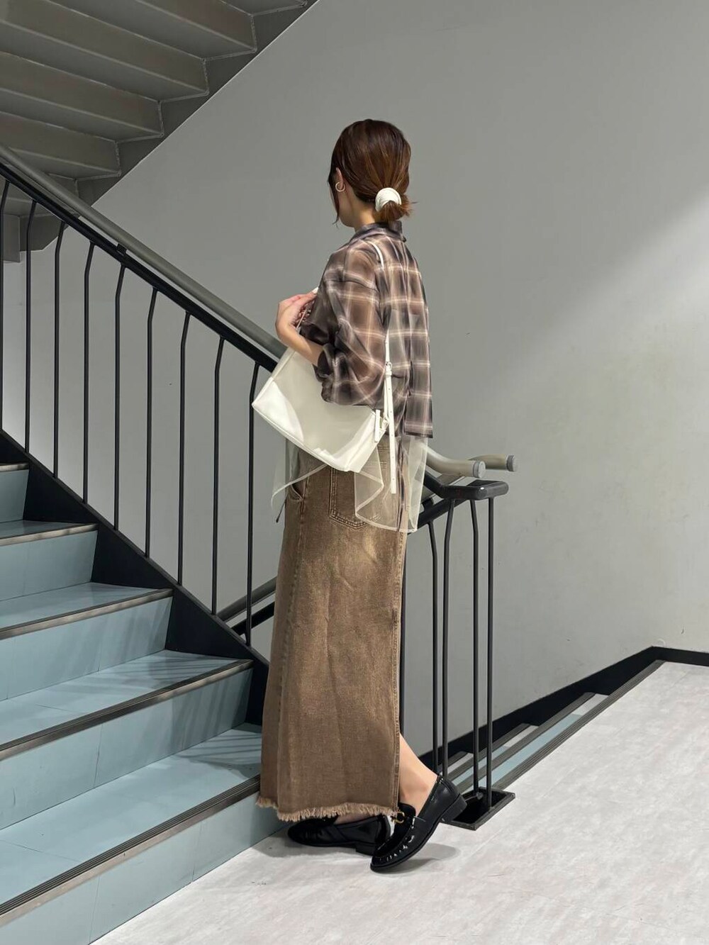 ホワイト系のショルダーバッグ、ブラウン系のスカート、ブラック系のローファーを着用したレディースの夏コーディネートの3枚目の写真