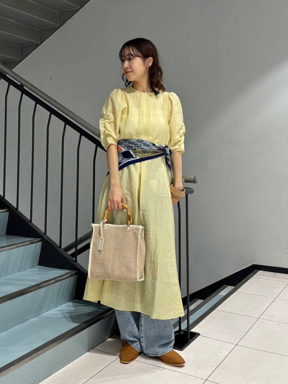 ブルー系のデニムパンツ、イエロー系のその他シューズ、ホワイト系のショルダーバッグを着用したレディースの春コーディネートの2枚目の写真