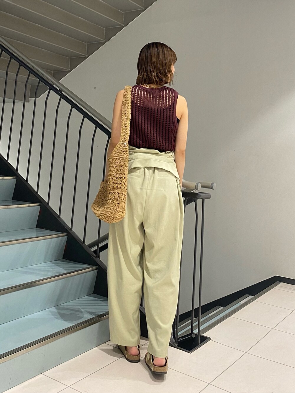 グリーン系のサロペット/オーバーオール、レッド系のタンクトップ、イエロー系のトートバッグを着用したレディースの夏コーディネートの3枚目の写真