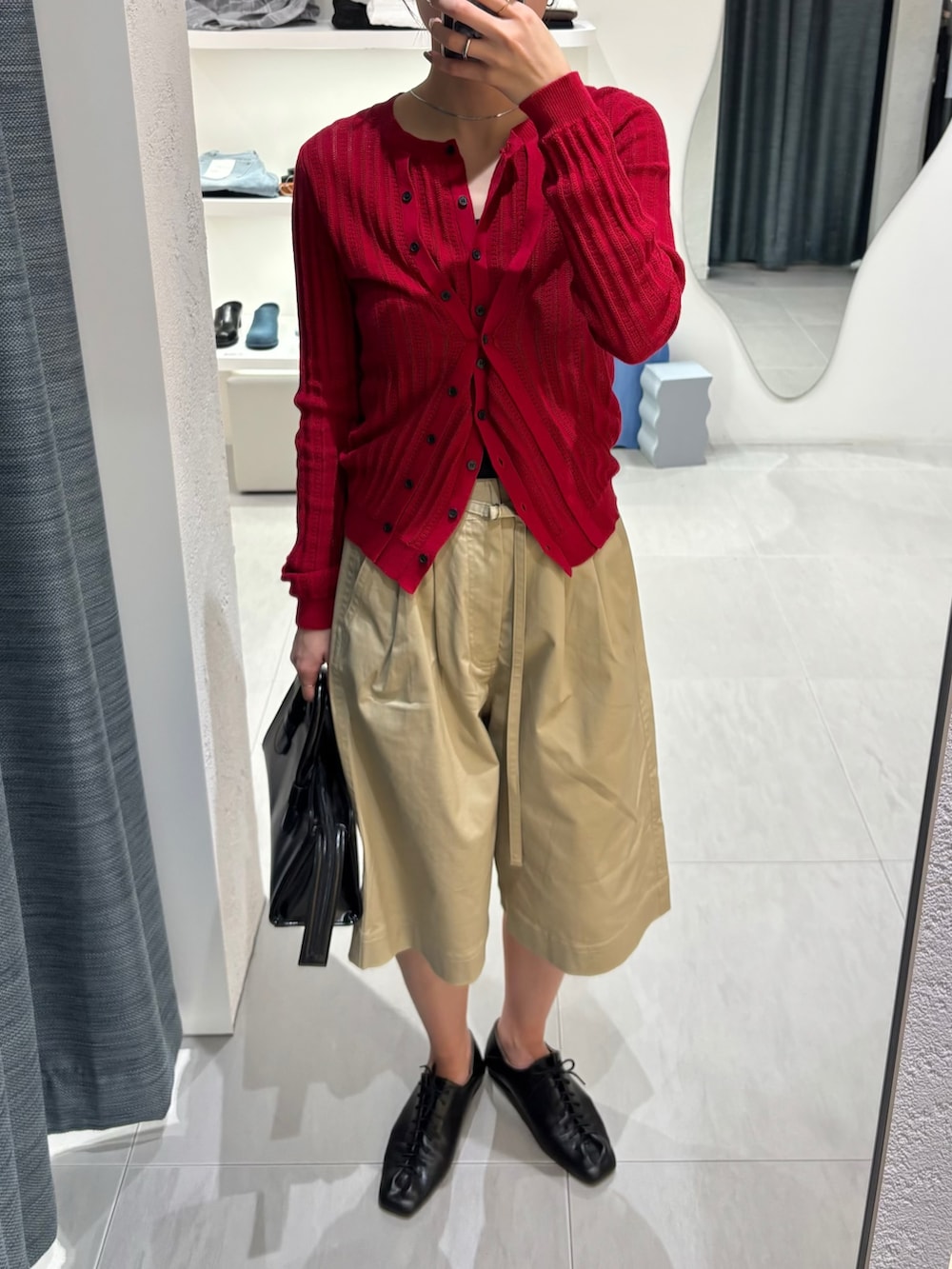 ベージュ系のその他パンツ、レッド系のニット/セーター、ブラック系のボストンバッグを着用したレディースの春コーディネートの5枚目の写真