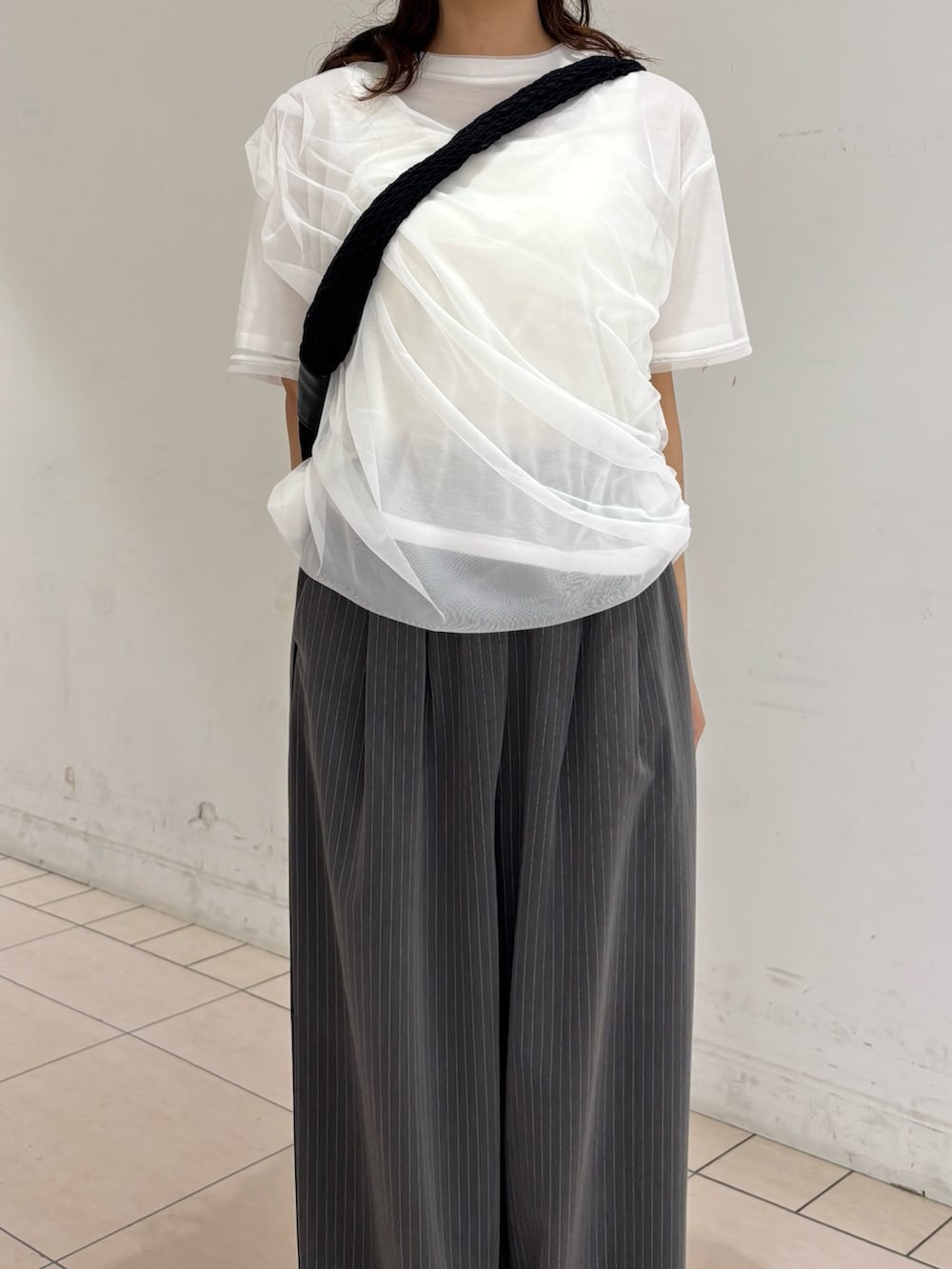 グレー系のその他パンツ、ホワイト系のTシャツ/カットソー、ホワイト系のショルダーバッグを着用したレディースの夏コーディネートの4枚目の写真