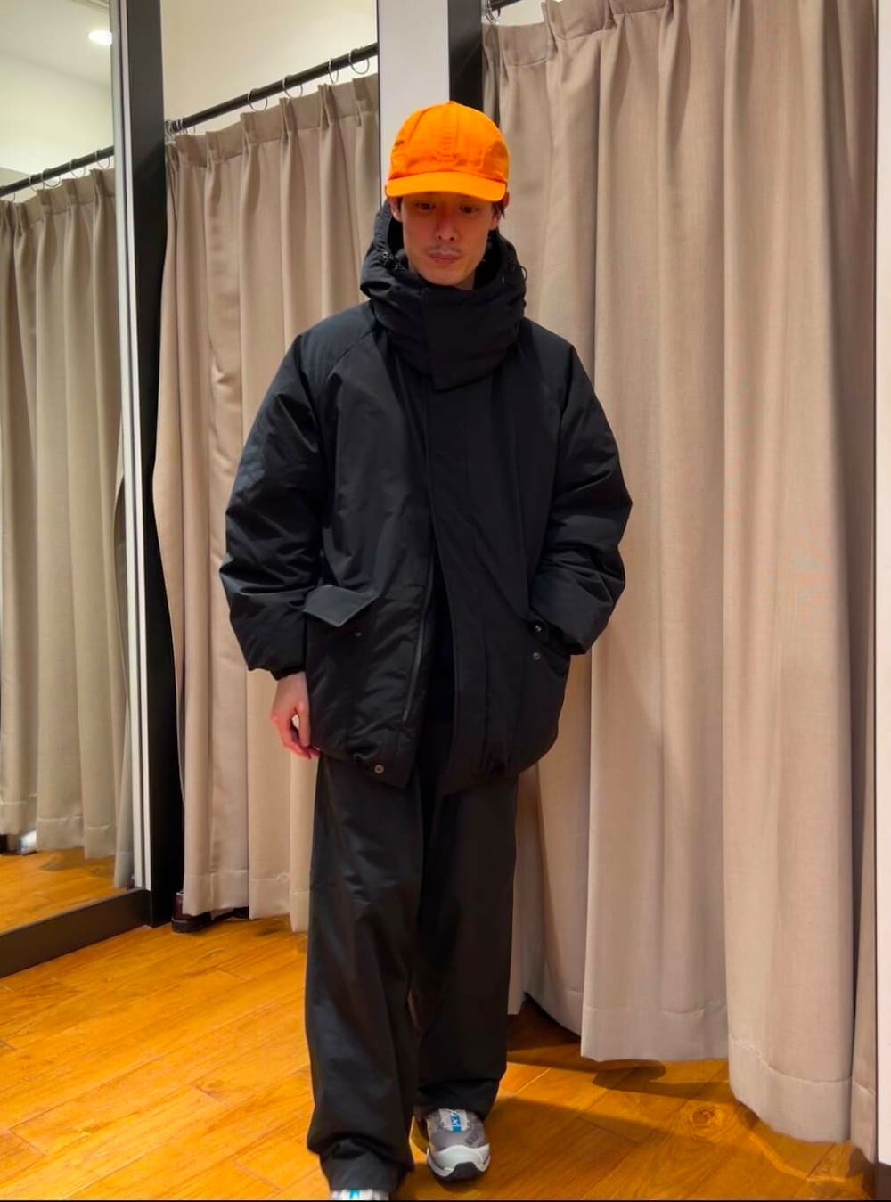 ブラック系のダウンジャケット/コート、シルバー系のスニーカー、ブルー系のニット/セーターを着用したメンズの冬コーディネートの3枚目の写真