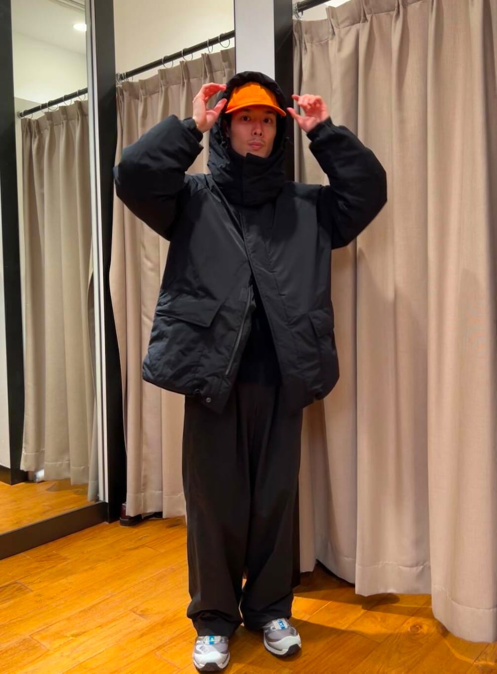 ブラック系のダウンジャケット/コート、シルバー系のスニーカー、ブルー系のニット/セーターを着用したメンズの冬コーディネートの5枚目の写真