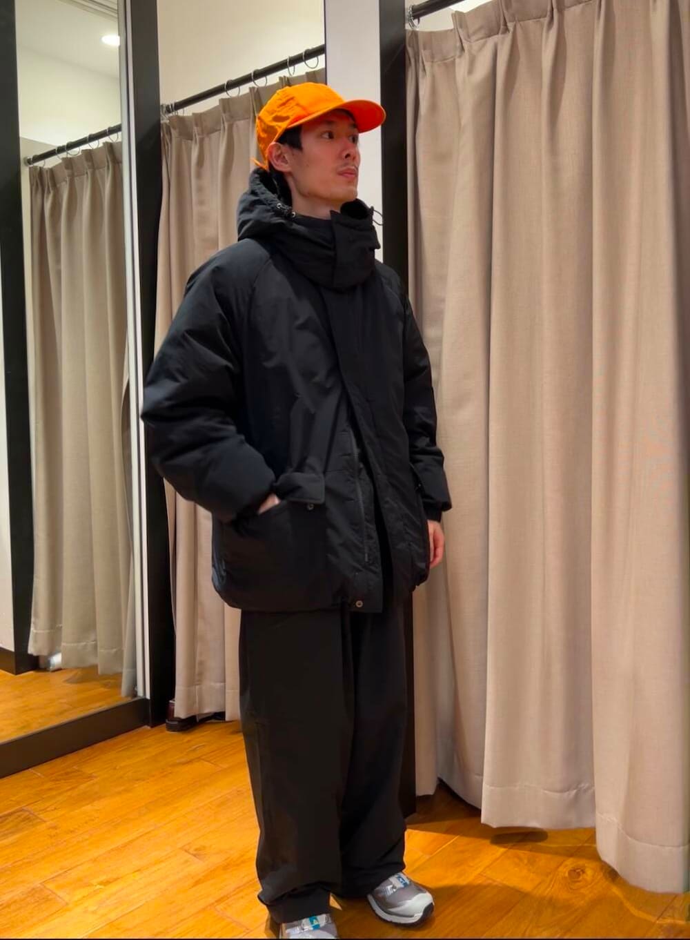 ブラック系のダウンジャケット/コート、シルバー系のスニーカー、ブルー系のニット/セーターを着用したメンズの冬コーディネートの4枚目の写真