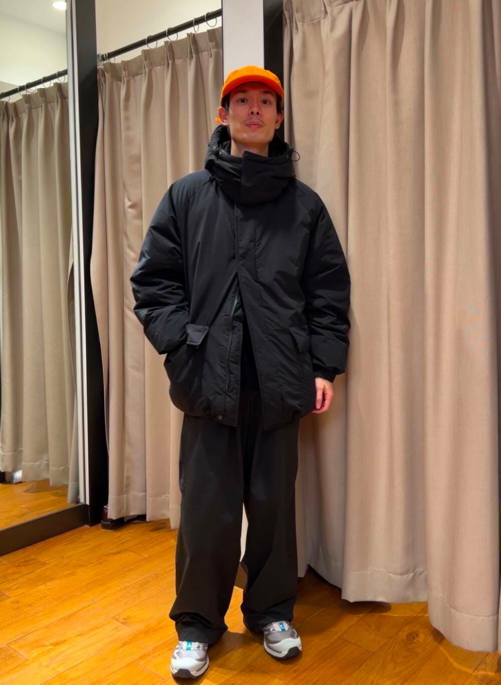 ブラック系のダウンジャケット/コート、シルバー系のスニーカー、ブルー系のニット/セーターを着用したメンズの冬コーディネートの2枚目の写真