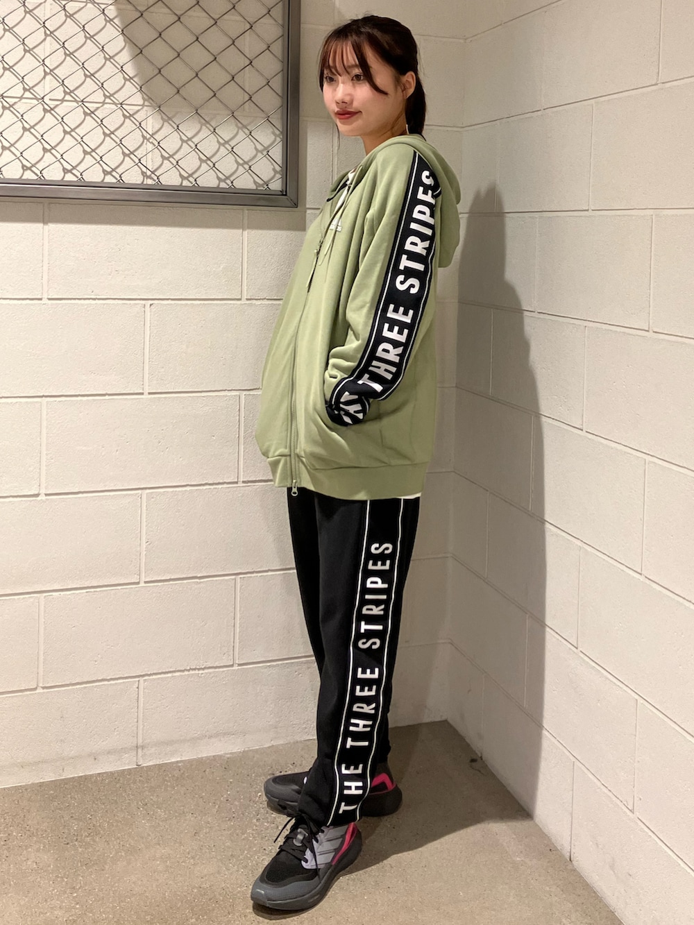 グリーン系のパーカー、ブラック系のその他パンツ、グレー系のシューズを着用したレディースの秋コーディネートの2枚目の写真