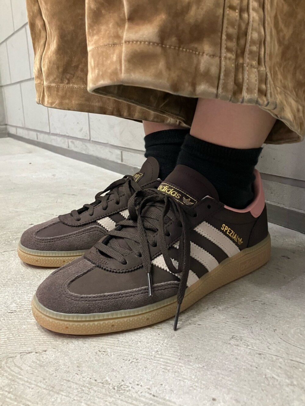 ブラック系のジャージ、ブラウン系のその他パンツ、ブラウン系のスニーカーを着用したレディースの秋コーディネートの6枚目の写真