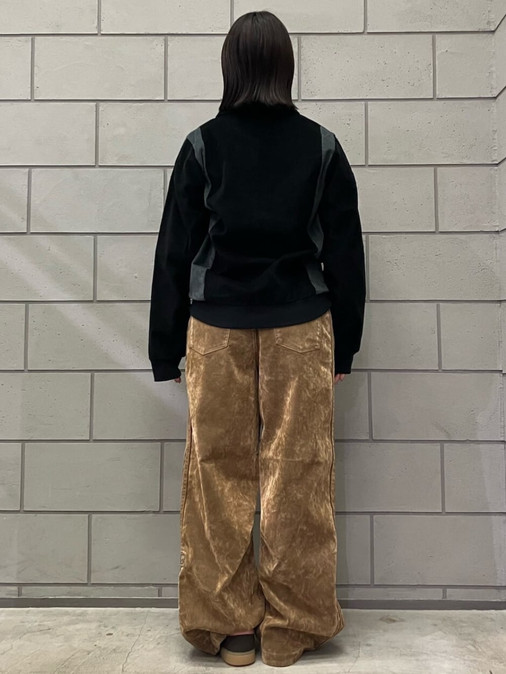 ブラック系のジャージ、ブラウン系のその他パンツ、ブラウン系のスニーカーを着用したレディースの秋コーディネートの3枚目の写真