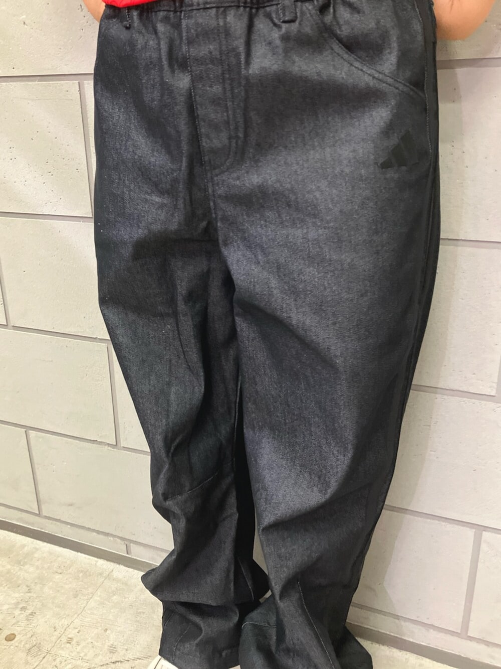 レッド系のTシャツ/カットソー、ブラック系のデニムパンツ、ホワイト系のスニーカーを着用したレディースの夏コーディネートの3枚目の写真