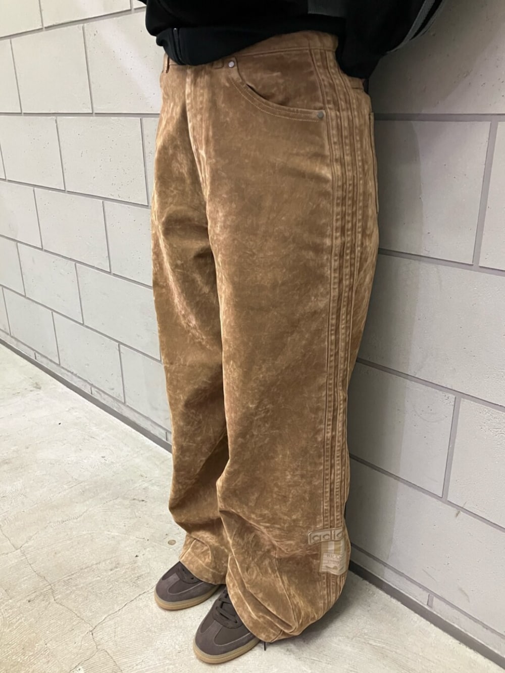 ブラック系のジャージ、ブラウン系のその他パンツ、ブラウン系のスニーカーを着用したレディースの秋コーディネートの5枚目の写真