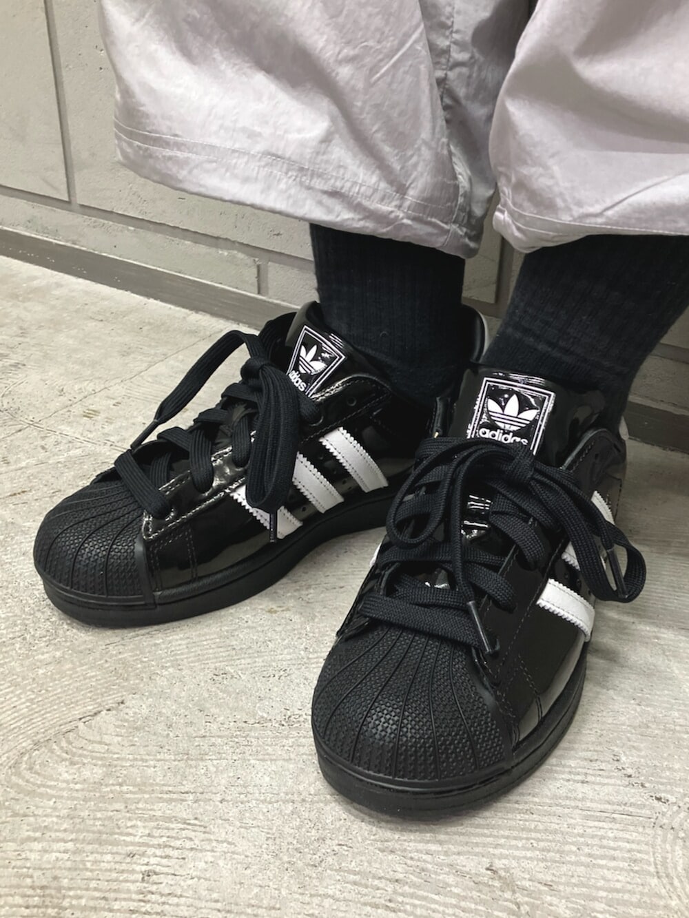 グレー系のその他パンツ、ブルー系のTシャツ/カットソー、ブラック系のスニーカーを着用したレディースの春コーディネートの6枚目の写真