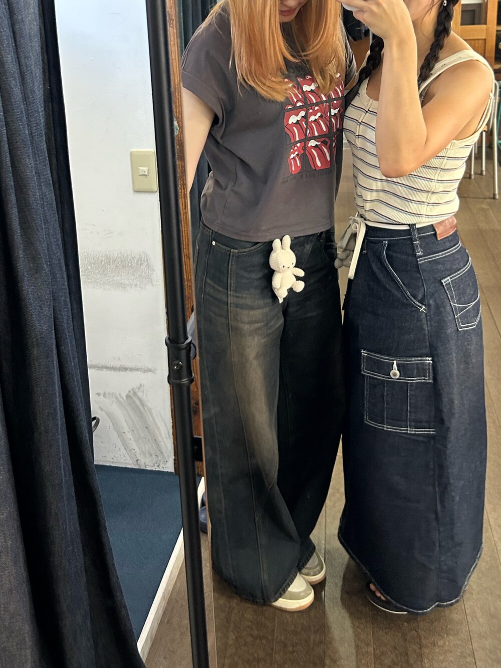 グレー系のTシャツ/カットソー、ブラック系のデニムパンツ、ベージュ系のスニーカーを着用したレディースの秋コーディネートの2枚目の写真