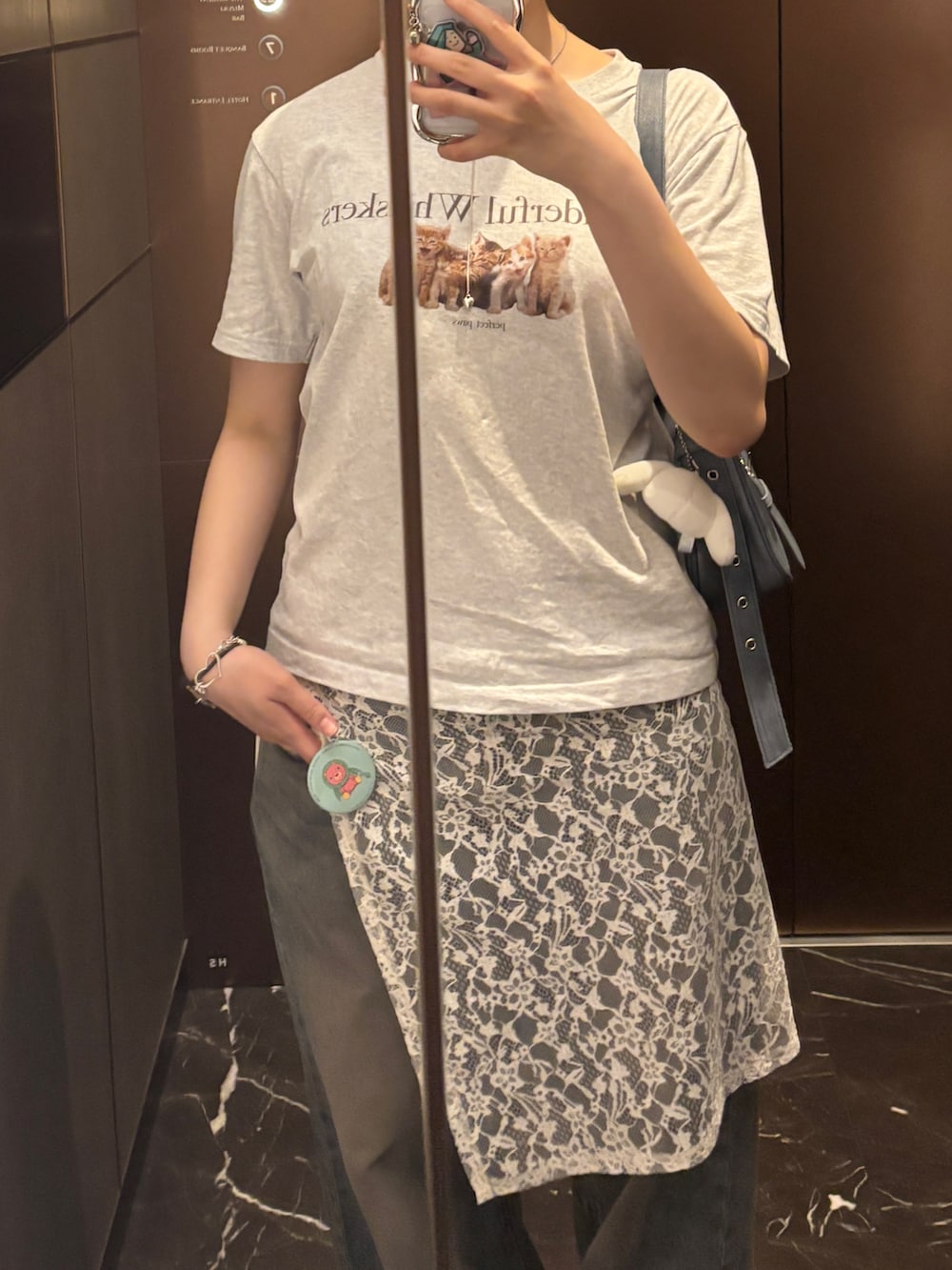 グレー系のTシャツ/カットソー、ブルー系のショルダーバッグ、ブルー系のデニムパンツを着用したレディースの秋コーディネートの2枚目の写真
