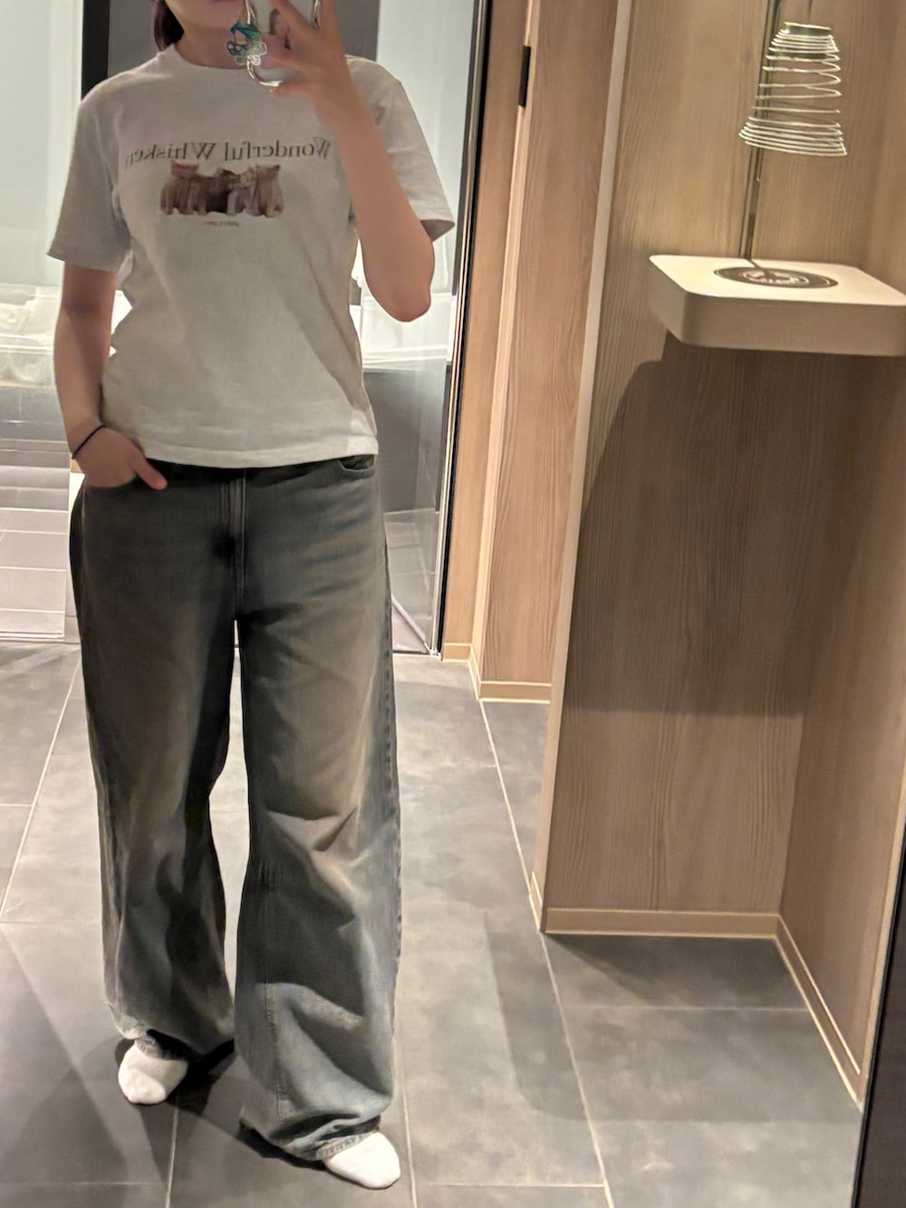 グレー系のTシャツ/カットソー、ブルー系のショルダーバッグ、ブルー系のデニムパンツを着用したレディースの秋コーディネートの3枚目の写真