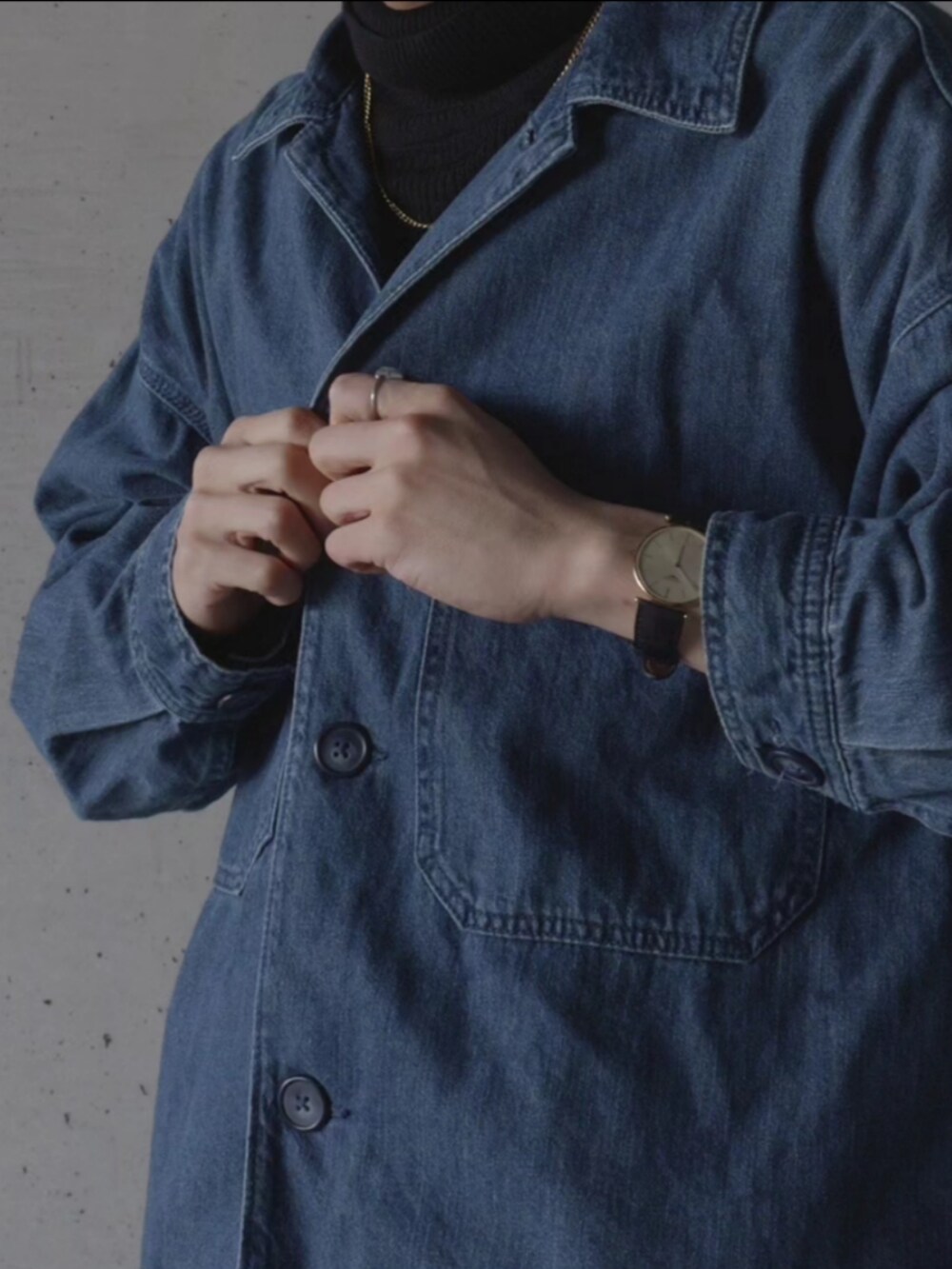 ブルー系のデニムジャケット、ブラック系のスラックスを着用したメンズの冬コーディネートの2枚目の写真