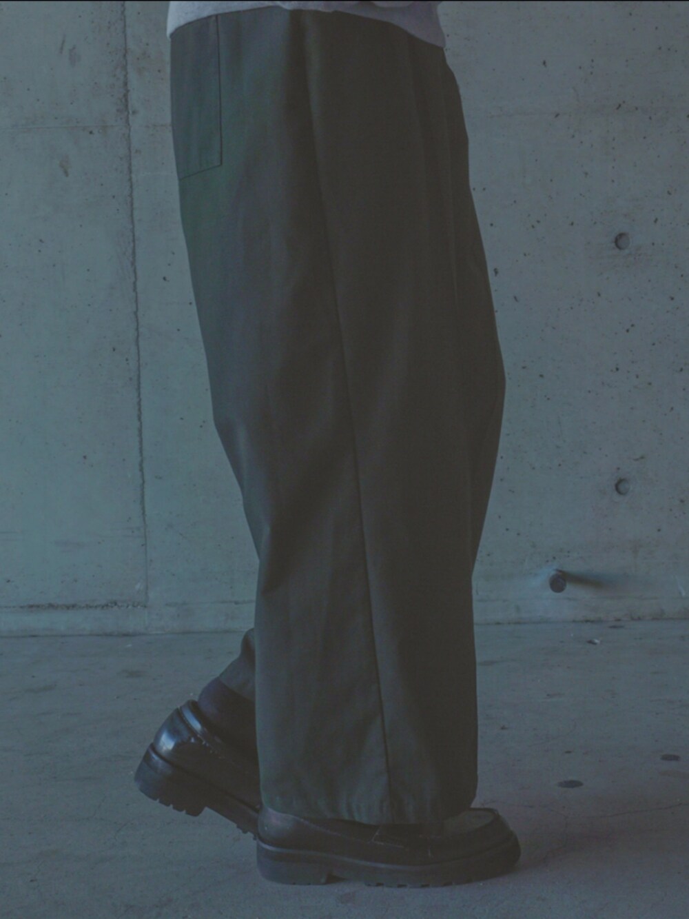 グリーン系のスラックス、グレー系のスウェットを着用したメンズの秋コーディネートの3枚目の写真