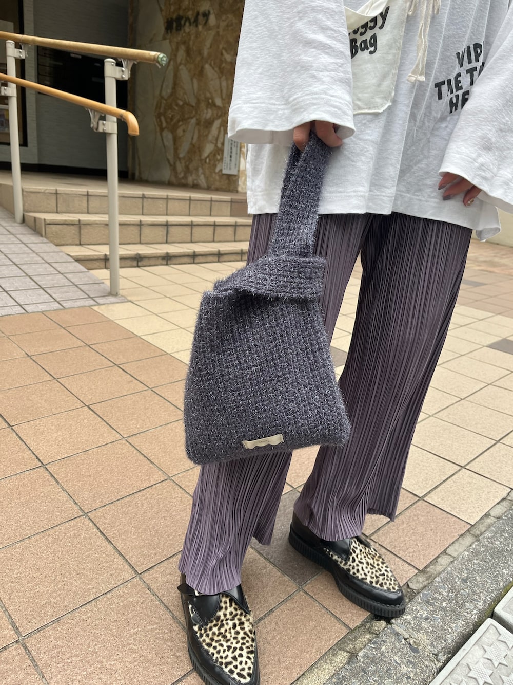 パープル系のトートバッグ、ホワイト系のTシャツ/カットソーを着用したレディースの秋コーディネートの2枚目の写真