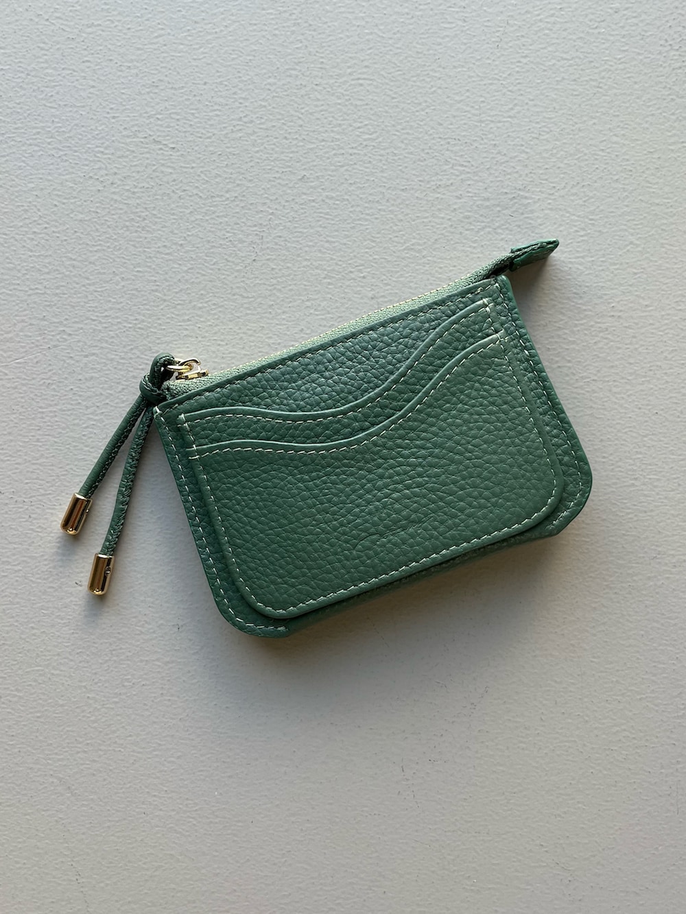 ホワイト系のエコバッグ/サブバッグ、グレー系のポーチ、グリーン系の財布を着用したレディースの冬コーディネートの3枚目の写真