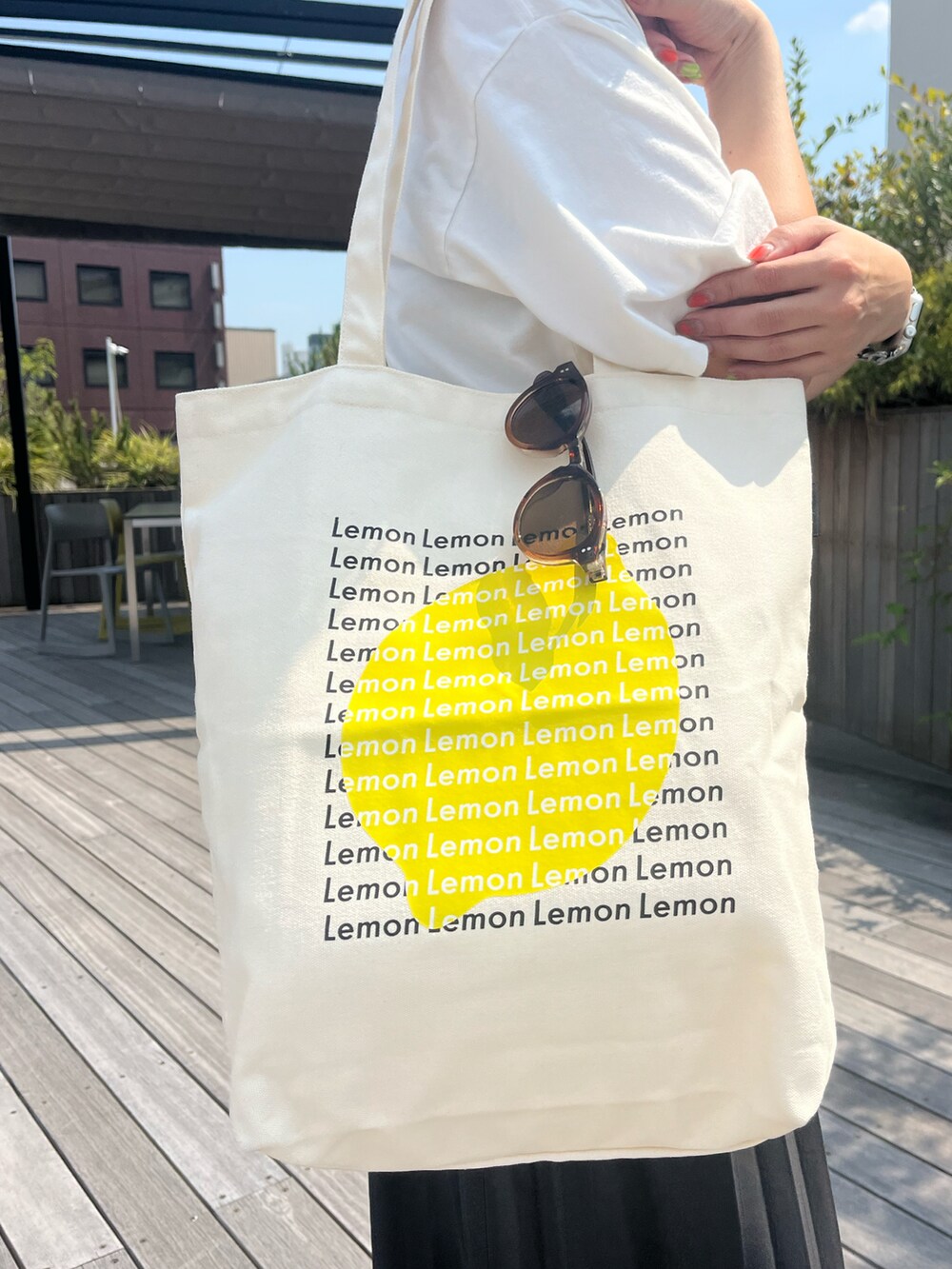 ホワイト系のトートバッグを着用したレディースの秋コーディネートの2枚目の写真