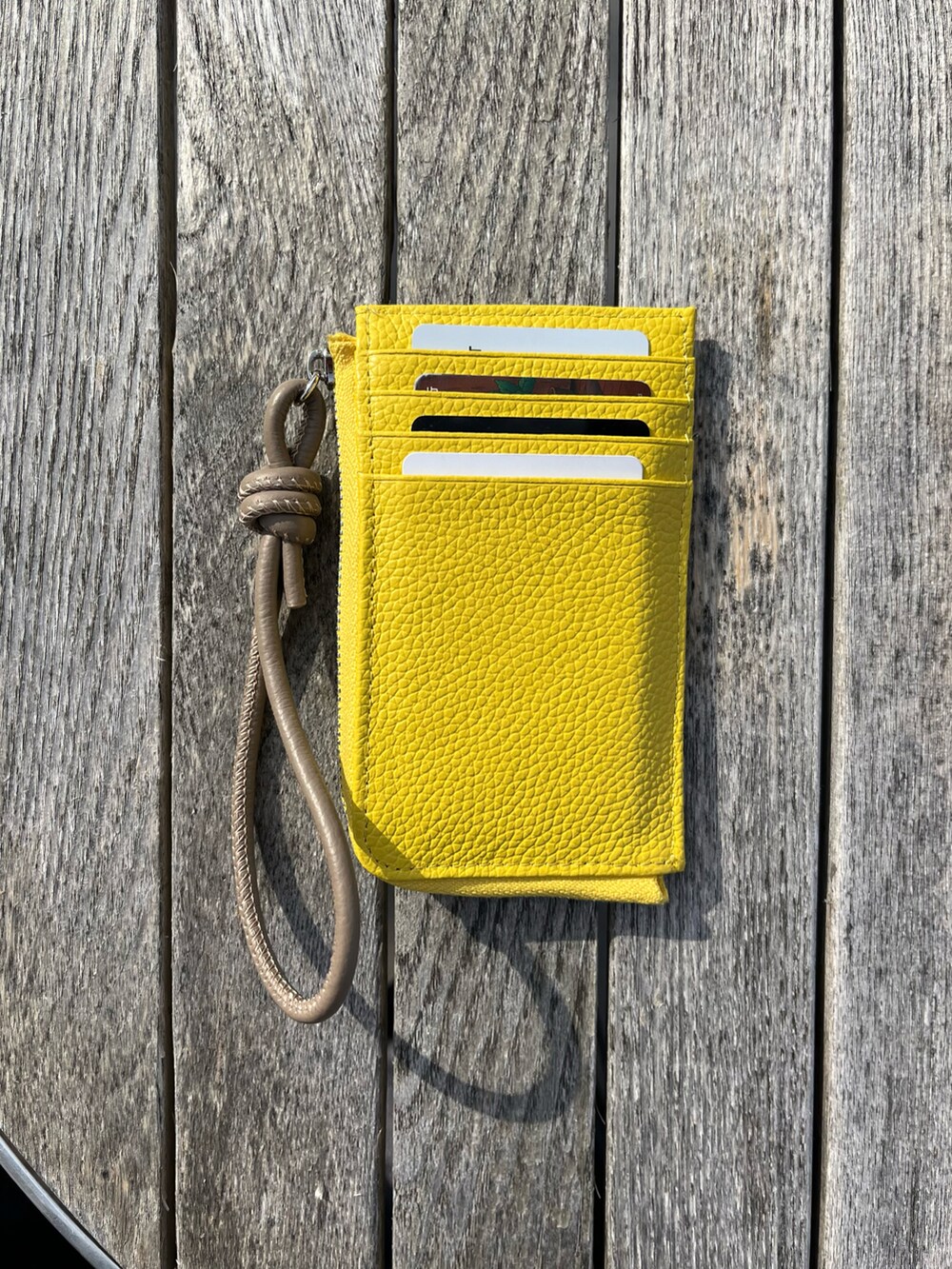 パープル系のトートバッグ、イエロー系の財布、ホワイト系のポーチを着用したレディースの春コーディネートの2枚目の写真