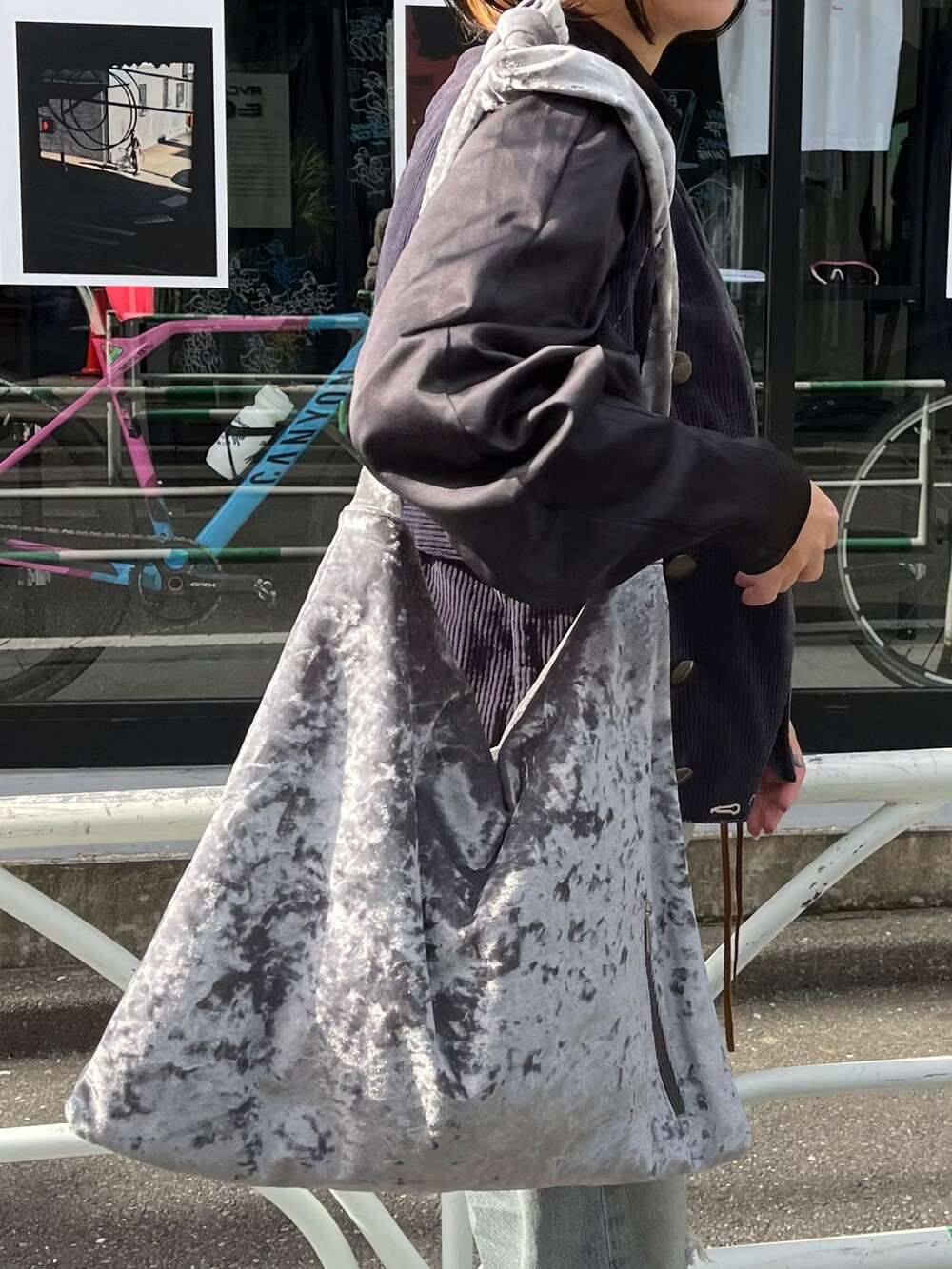 グレー系のトートバッグ、ブルー系のデニムパンツ、グリーン系のソックス/靴下を着用したレディースの秋コーディネートの3枚目の写真