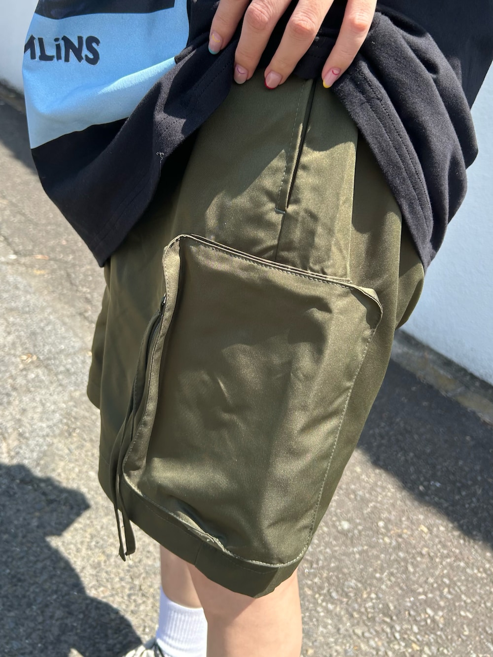 ブラック系のTシャツ/カットソー、グリーン系のその他パンツ、ホワイト系のスニーカーを着用したレディースの夏コーディネートの3枚目の写真