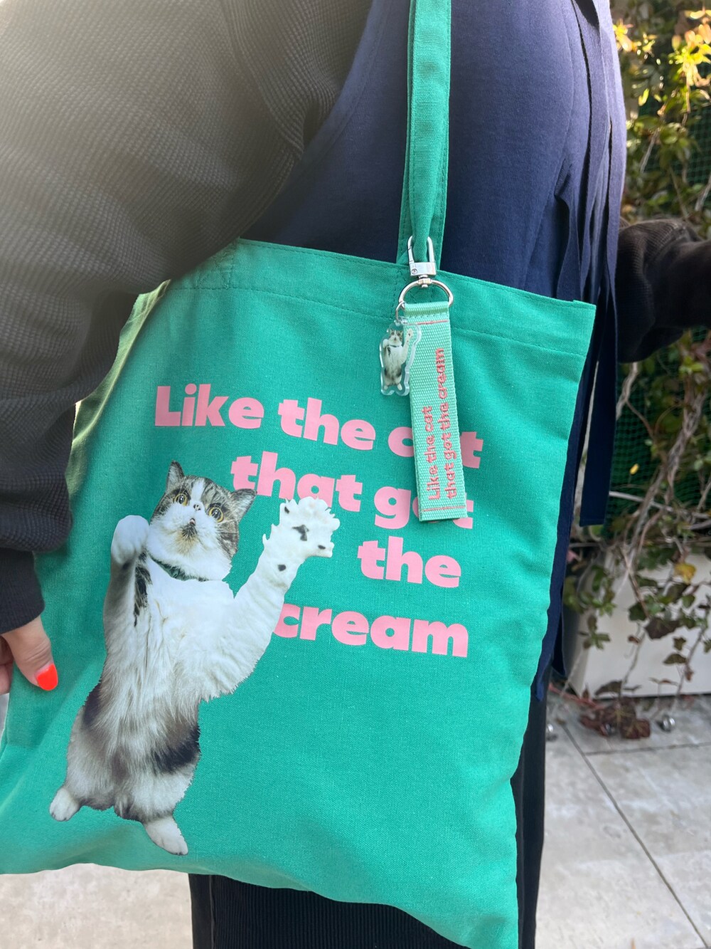 グリーン系のトートバッグ、ブラック系のトップス、ブラック系のその他パンツを着用したレディースの冬コーディネートの2枚目の写真