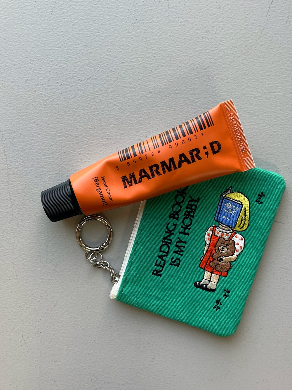 ゴールド系の財布、グリーン系のポーチ、ブルー系のチャームを着用したレディースの冬コーディネートの5枚目の写真