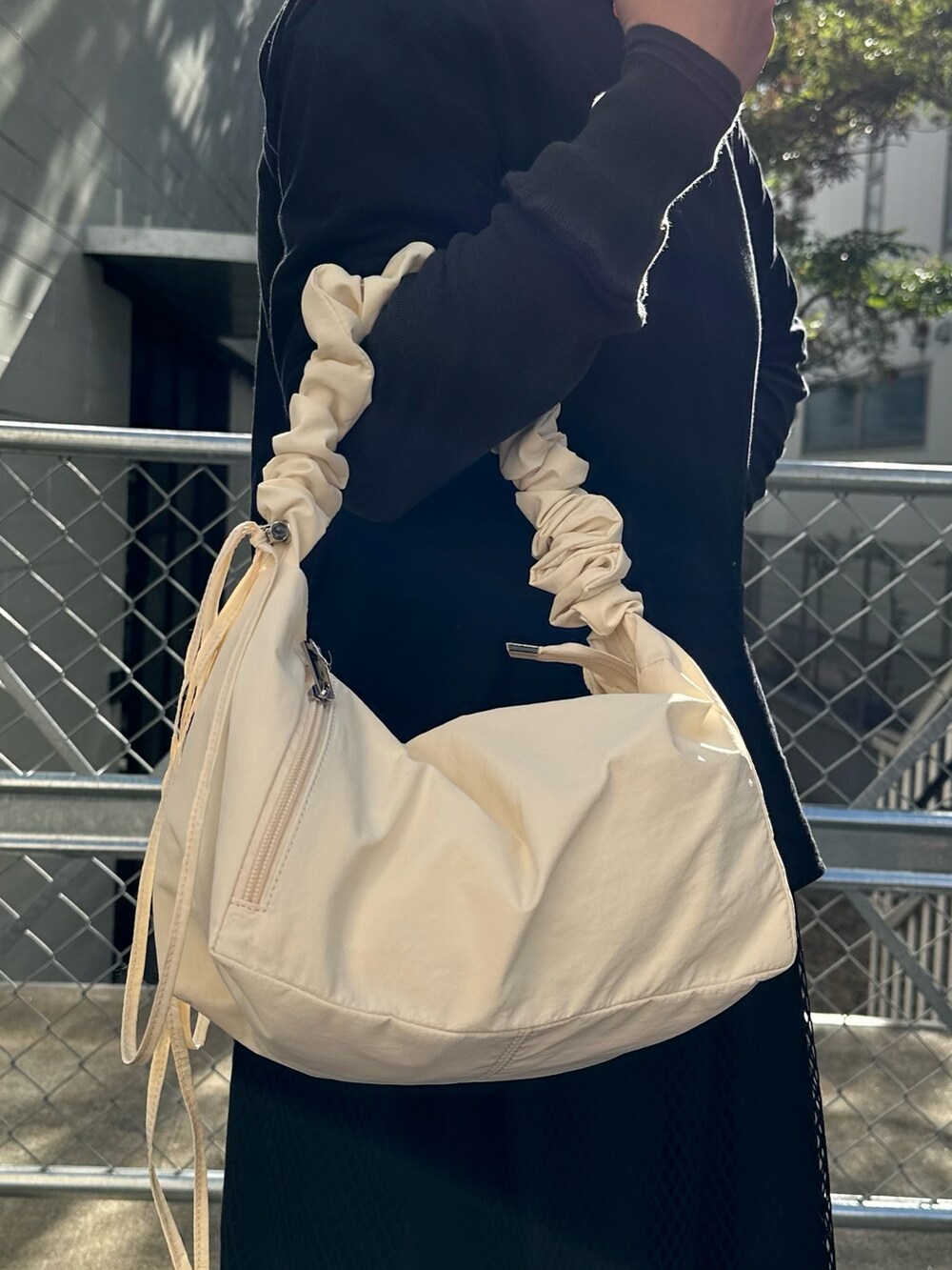 ホワイト系のショルダーバッグ、ホワイト系のスニーカーを着用したレディースの冬コーディネートの2枚目の写真