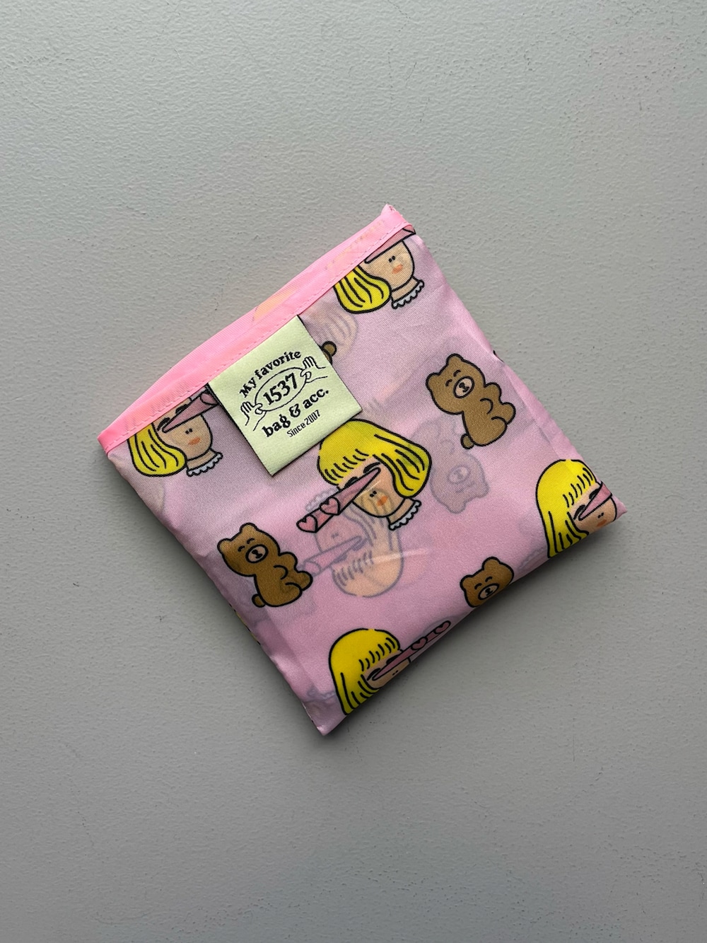 ピンク系のエコバッグ/サブバッグ、ベージュ系の財布、ピンク系のポーチを着用したレディースの秋コーディネートの2枚目の写真