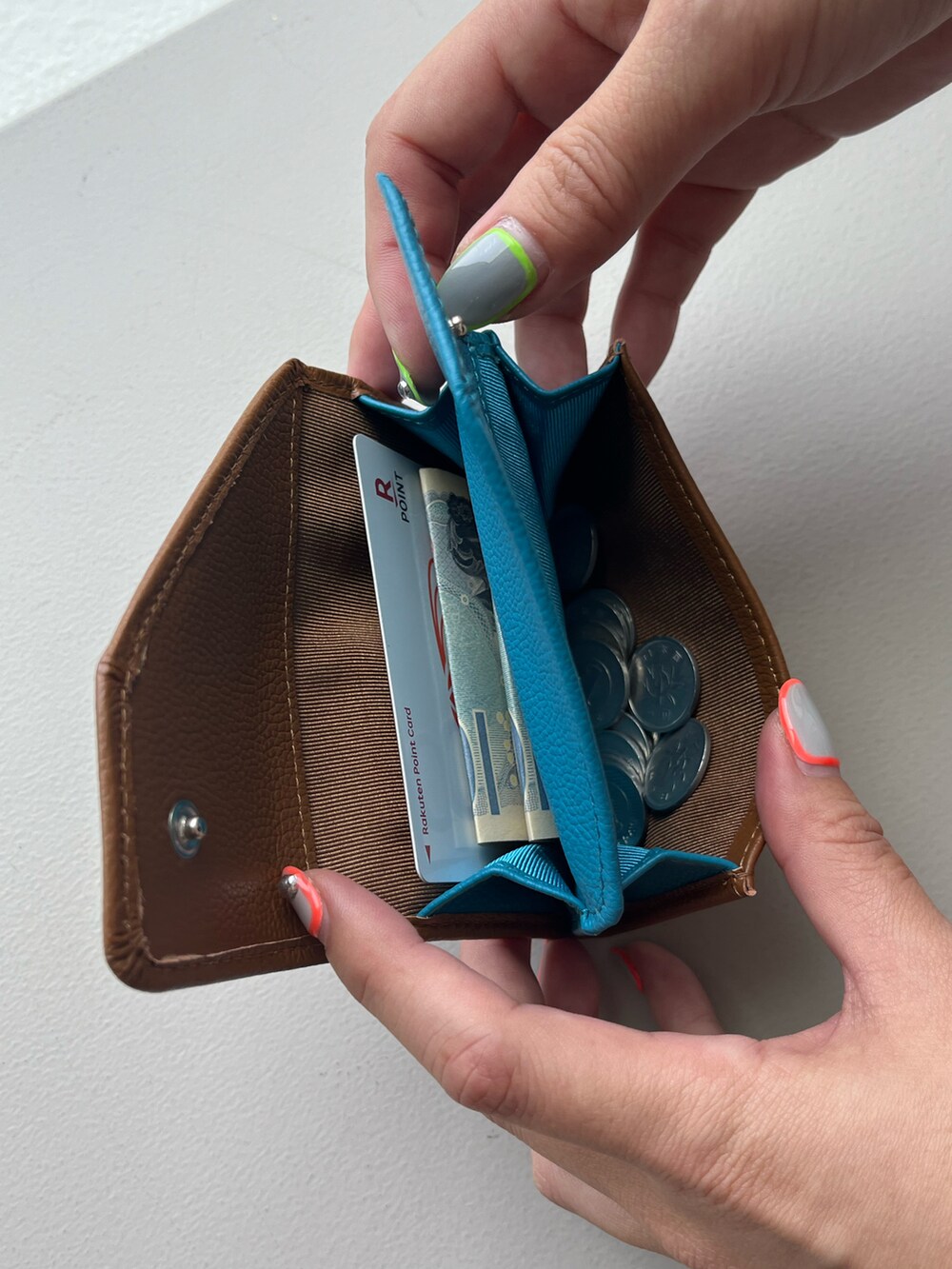 グリーン系の生活家電、イエロー系の名刺入れ、シルバー系の財布を着用したレディースの春コーディネートの3枚目の写真