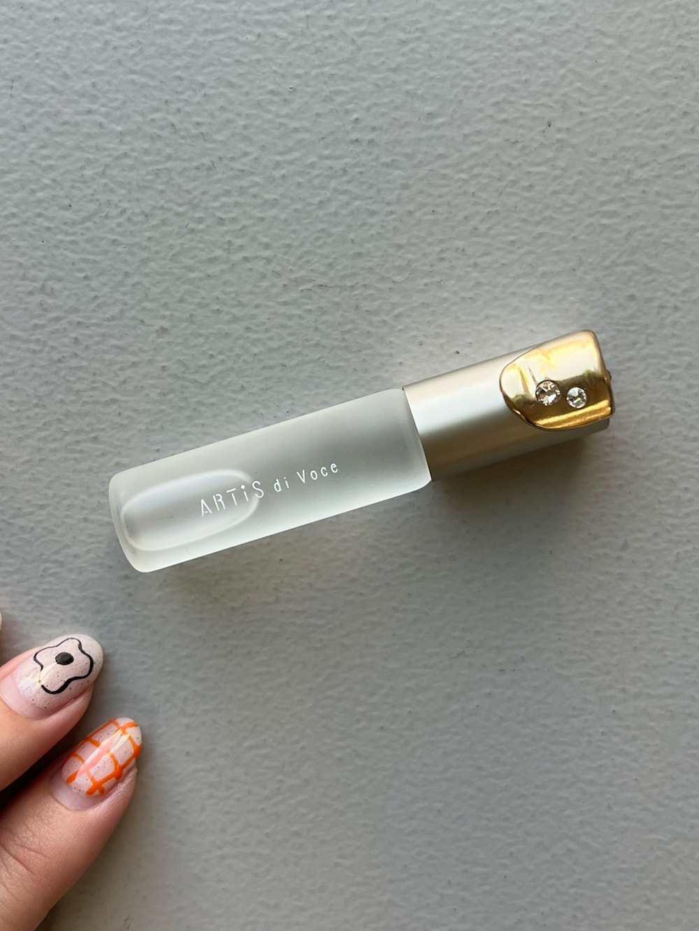 ゴールド系の財布、グリーン系のポーチ、ブルー系のチャームを着用したレディースの冬コーディネートの3枚目の写真