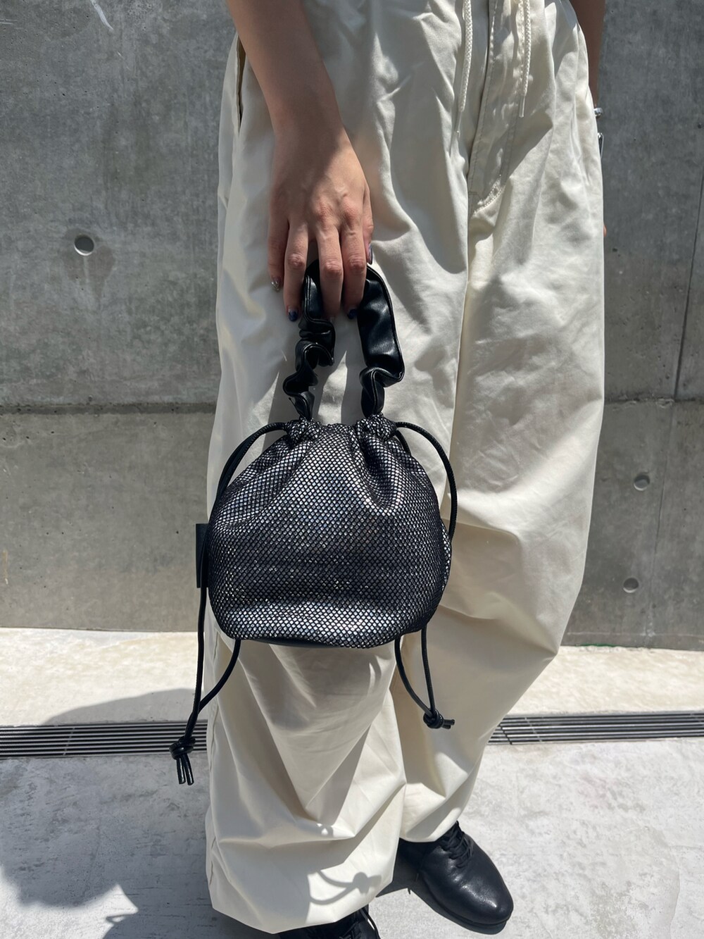 ホワイト系のその他パンツ、シルバー系のトートバッグ、ブラック系のドレスシューズを着用したレディースの夏コーディネートの2枚目の写真