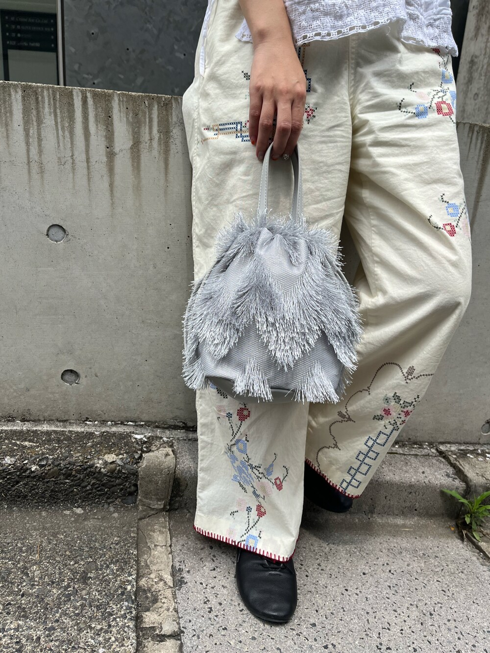 ホワイト系のその他パンツ、ブラック系のドレスシューズ、グレー系のトートバッグを着用したレディースの夏コーディネートの2枚目の写真