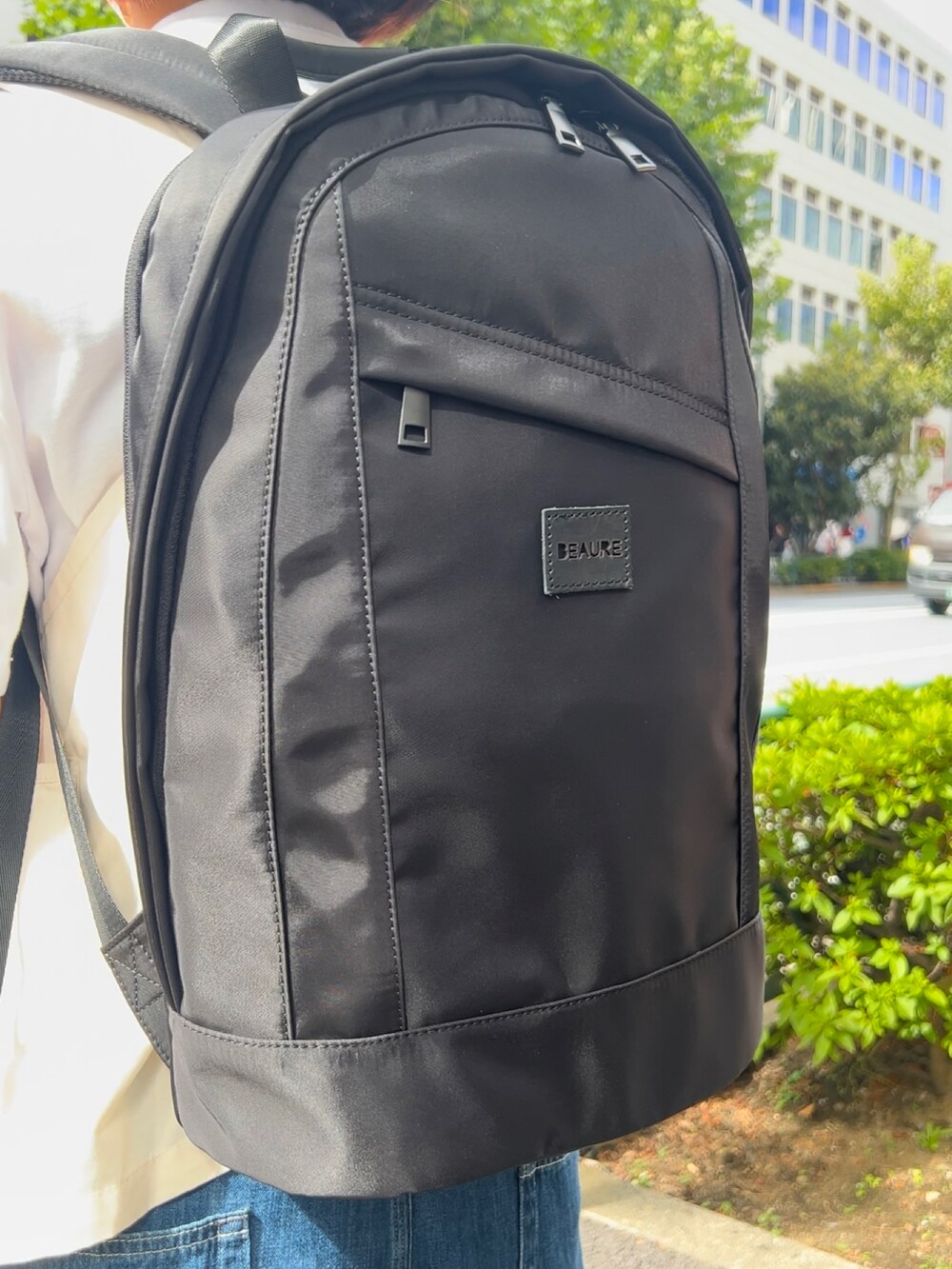 ブラック系のバックパック/リュック、ブルー系のデニムパンツ、ホワイト系のスニーカーを着用したレディースの秋コーディネートの2枚目の写真