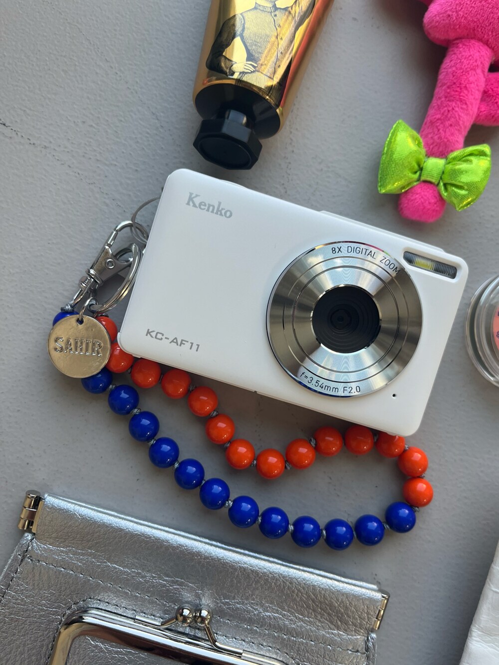 ホワイト系のカメラ/カメラグッズ、その他のハンドケア/ハンドクリーム、ブルー系のキーホルダーを着用したレディースの春コーディネートの2枚目の写真