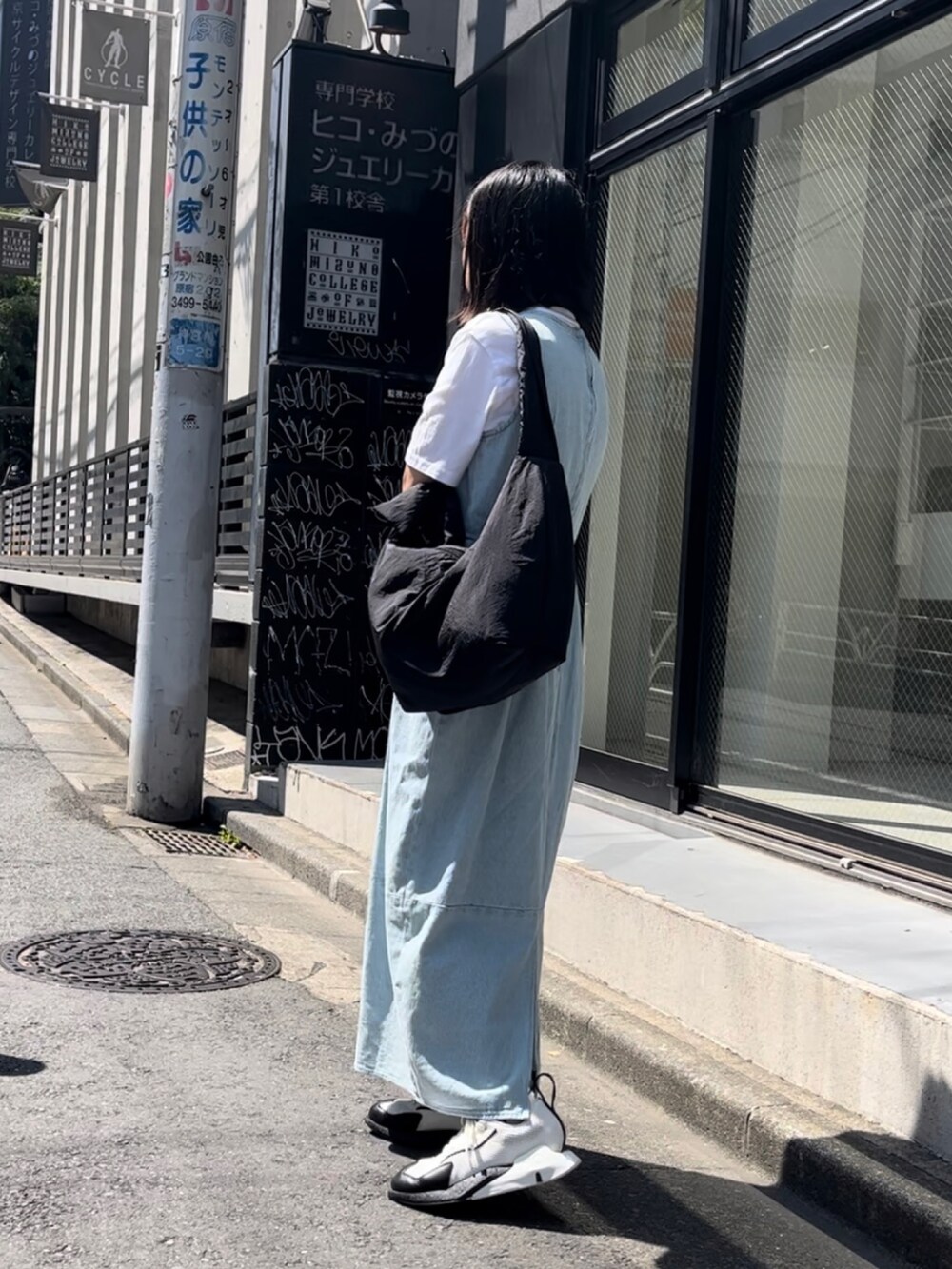 ブラック系のショルダーバッグ、ホワイト系のスニーカー、シルバー系のネックレスを着用したレディースの夏コーディネートの2枚目の写真