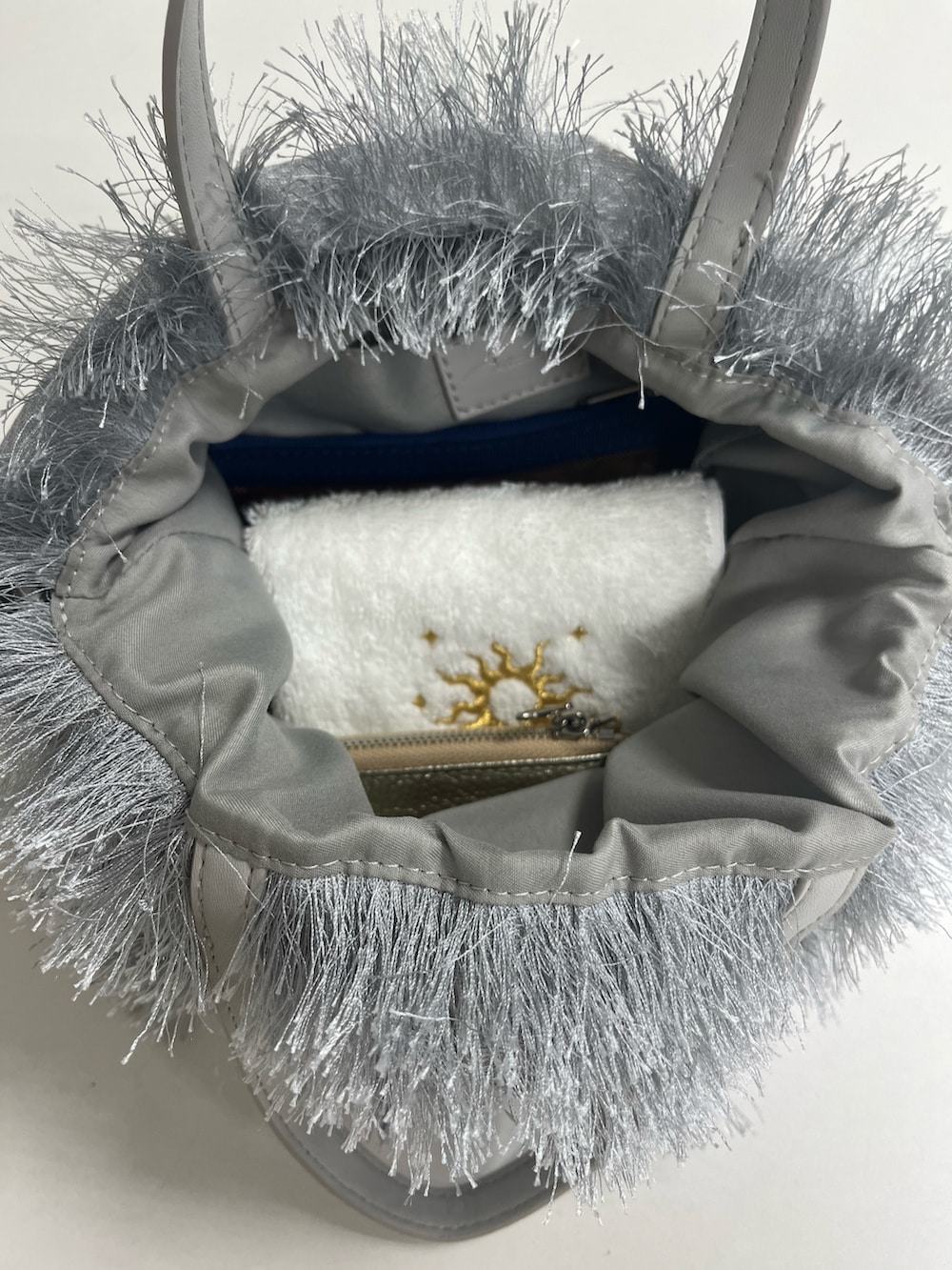 グレー系のトートバッグ、ホワイト系のハンカチ/ハンドタオル、オレンジ系のポーチを着用したレディースの夏コーディネートの3枚目の写真