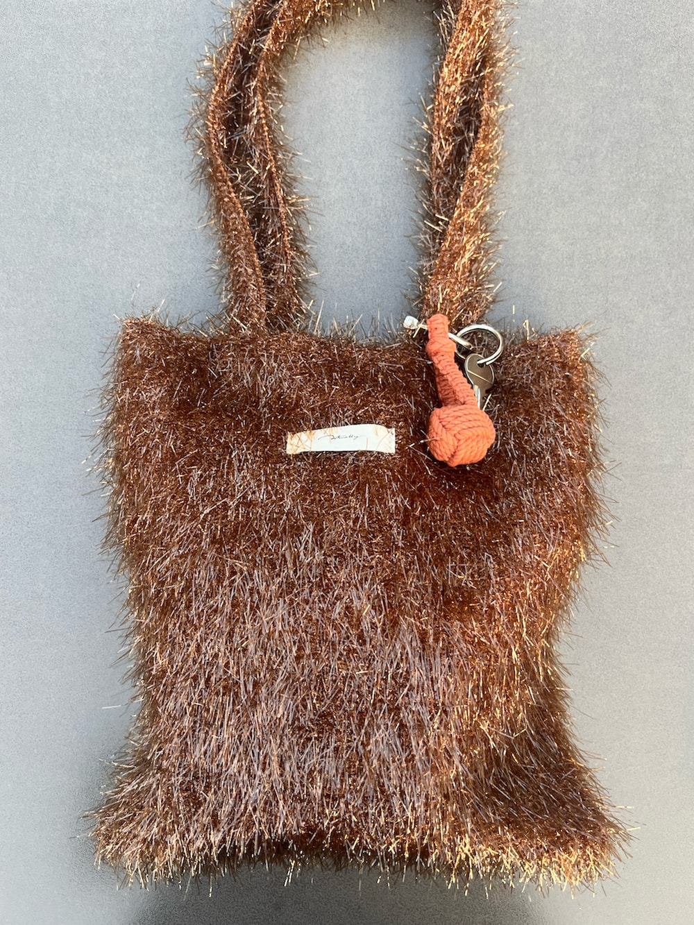 ブラウン系のトートバッグ、イエロー系のボディケア/ボディクリーム、イエロー系のヘアブラシを着用したレディースの秋コーディネートの2枚目の写真