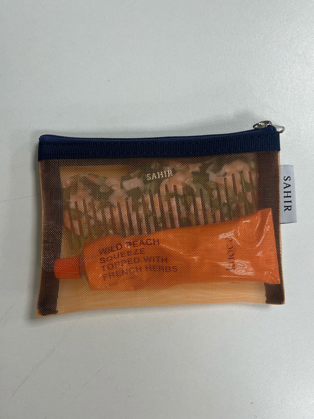 グレー系のトートバッグ、ホワイト系のハンカチ/ハンドタオル、オレンジ系のポーチを着用したレディースの夏コーディネートの2枚目の写真