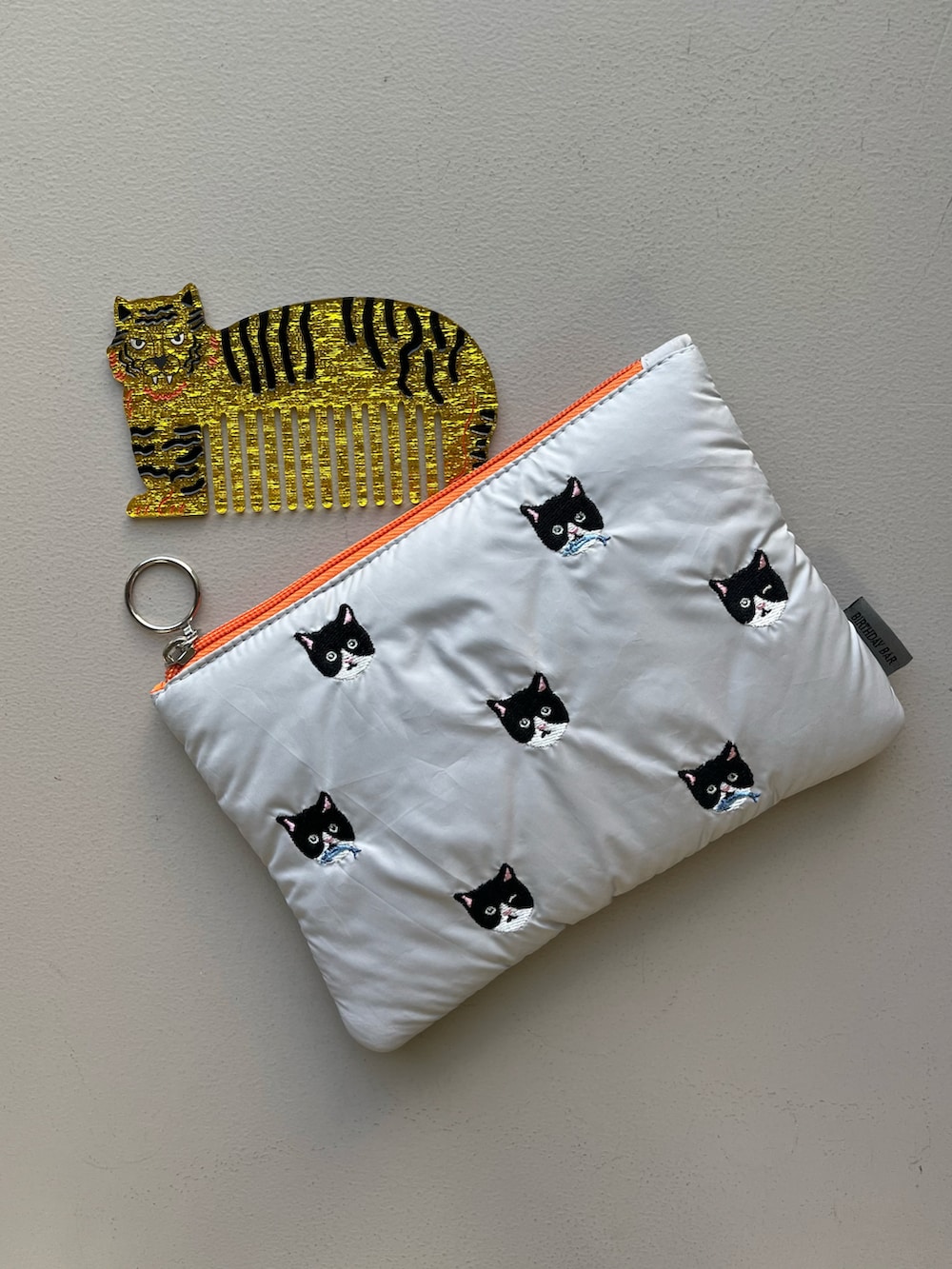 その他のハンドケア/ハンドクリーム、グレー系のポーチ、イエロー系の財布を着用したレディースの冬コーディネートの2枚目の写真