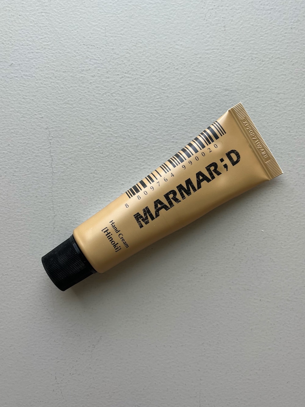 ゴールド系のパスケース、ホワイト系のチャーム、その他の香水を着用したレディースの夏コーディネートの2枚目の写真