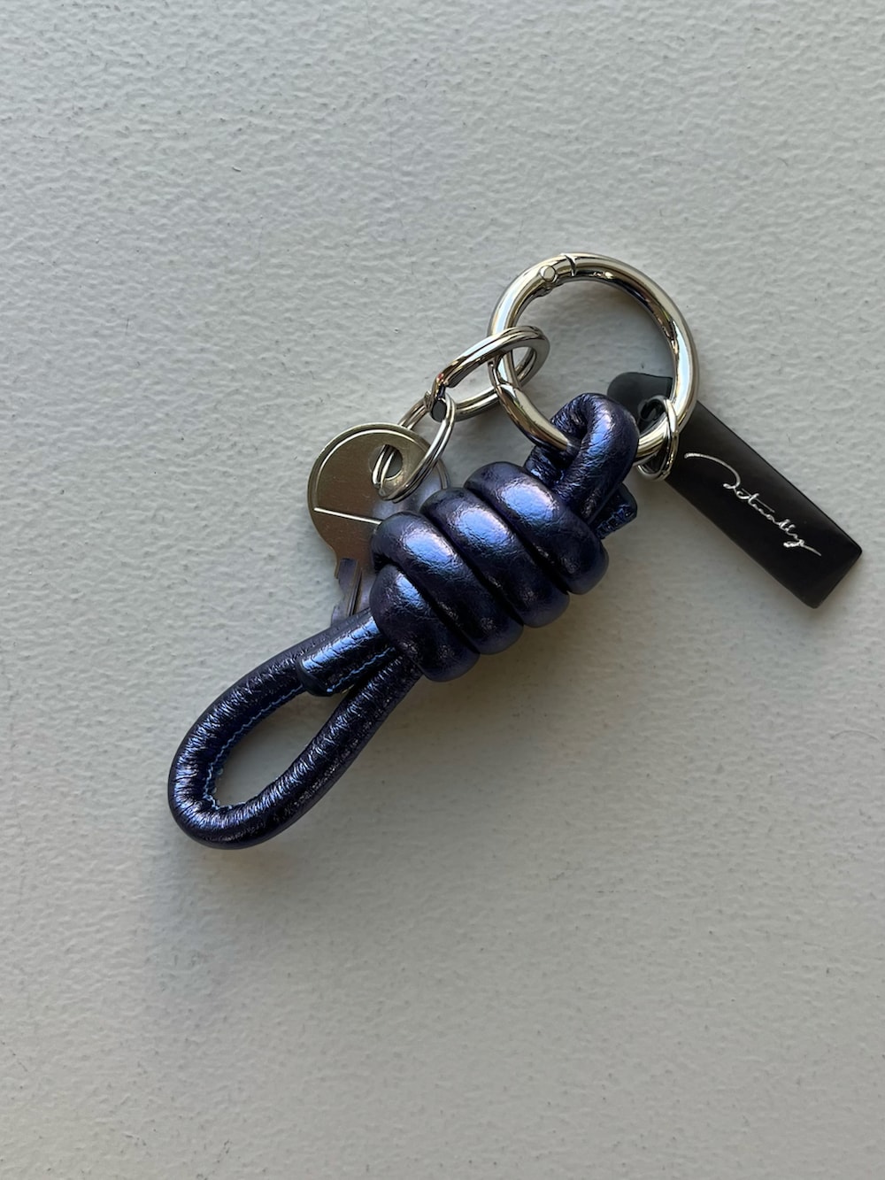 ゴールド系の財布、グリーン系のポーチ、ブルー系のチャームを着用したレディースの冬コーディネートの4枚目の写真