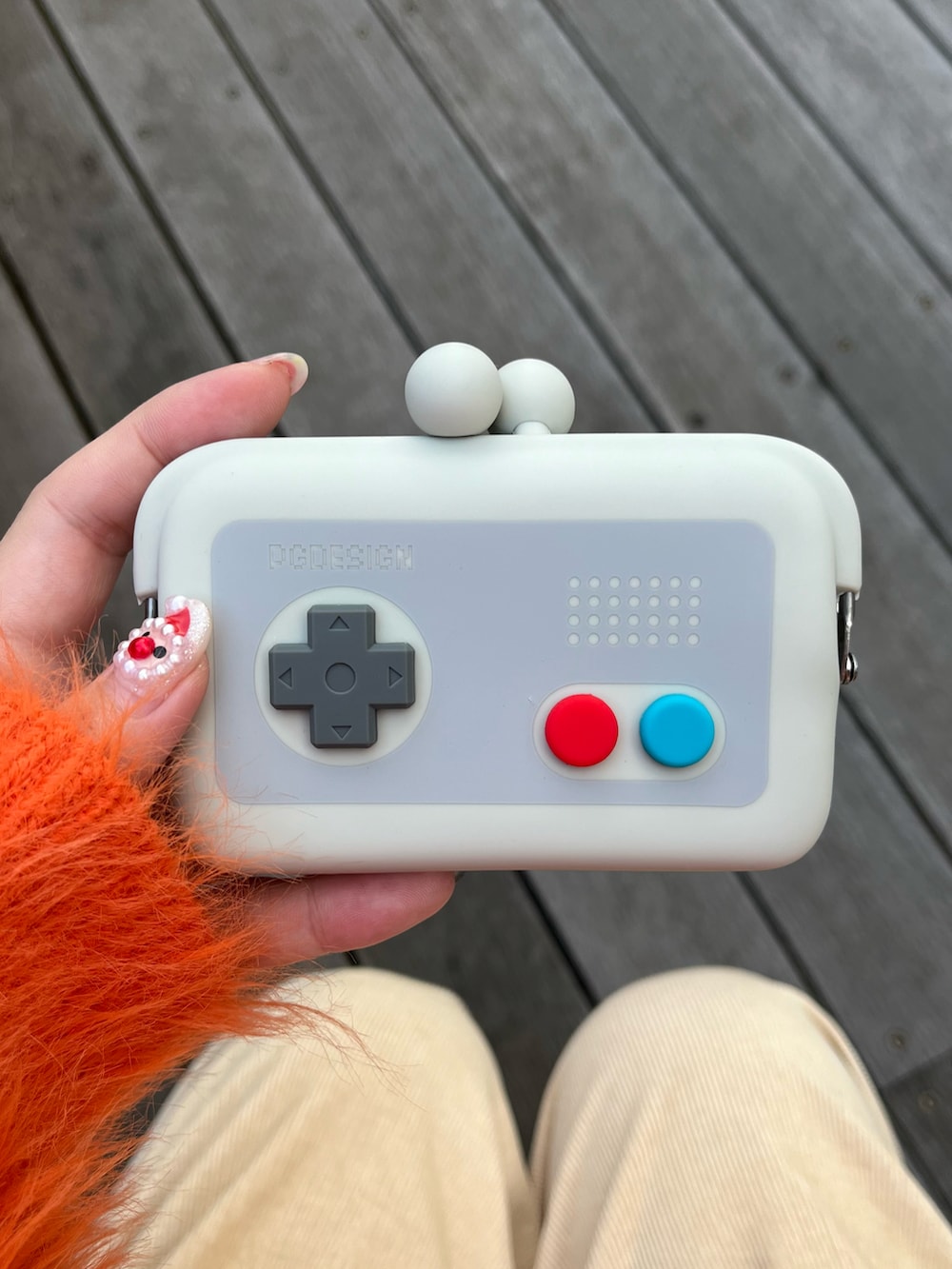 グレー系のポーチ、ホワイト系のチャーム、ホワイト系のチャームを着用したレディースの冬コーディネートの3枚目の写真