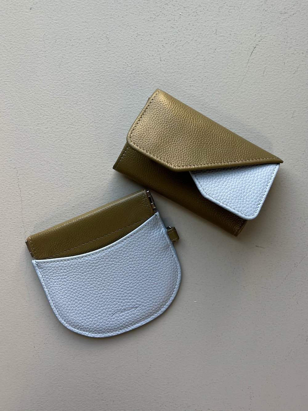 グレー系のポーチ、ホワイト系のハンカチ/ハンドタオル、グリーン系の名刺入れを着用したレディースの秋コーディネートの3枚目の写真