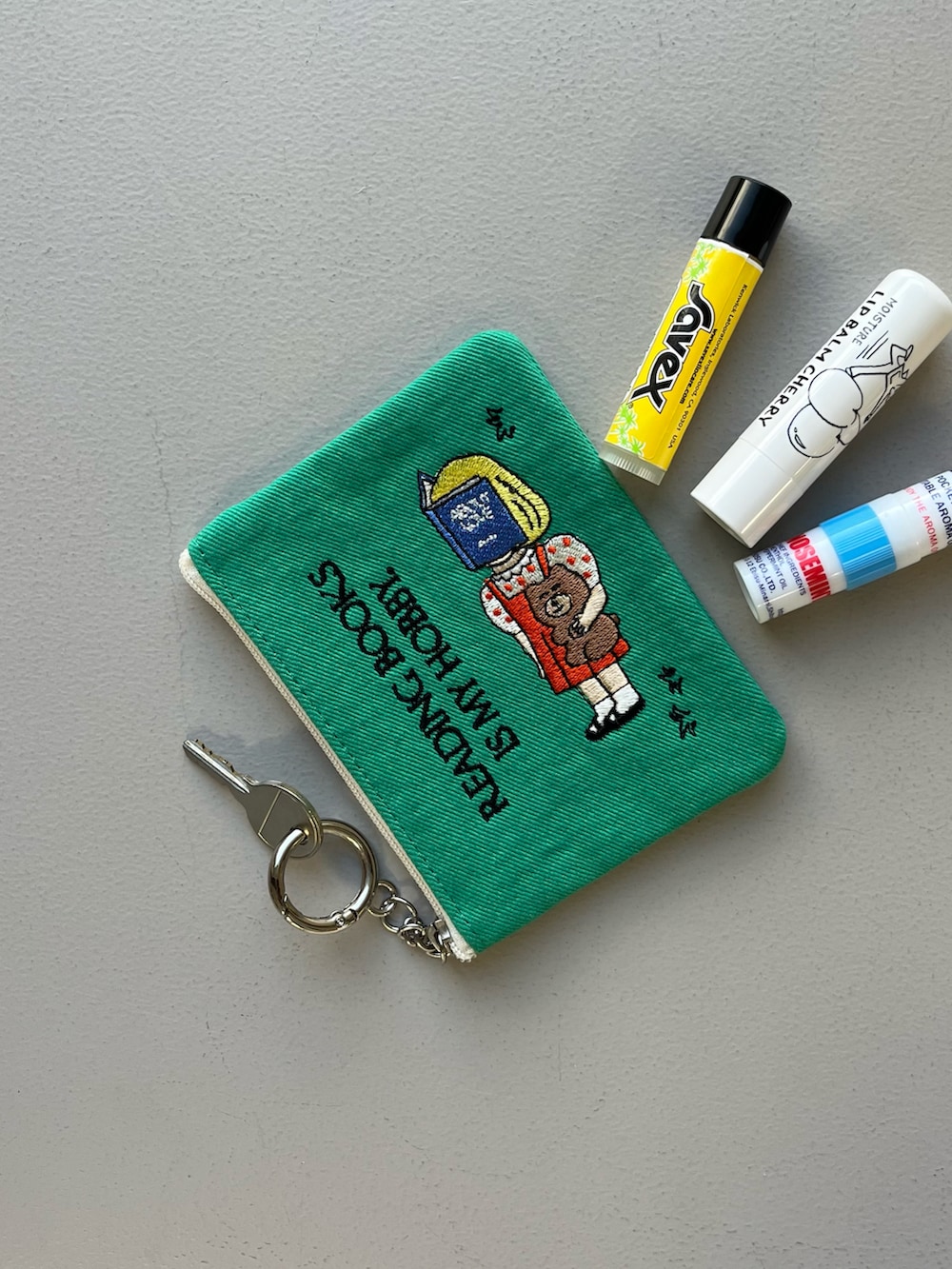 シルバー系の財布、ベージュ系のカードケース、グリーン系のポーチを着用したレディースの冬コーディネートの4枚目の写真